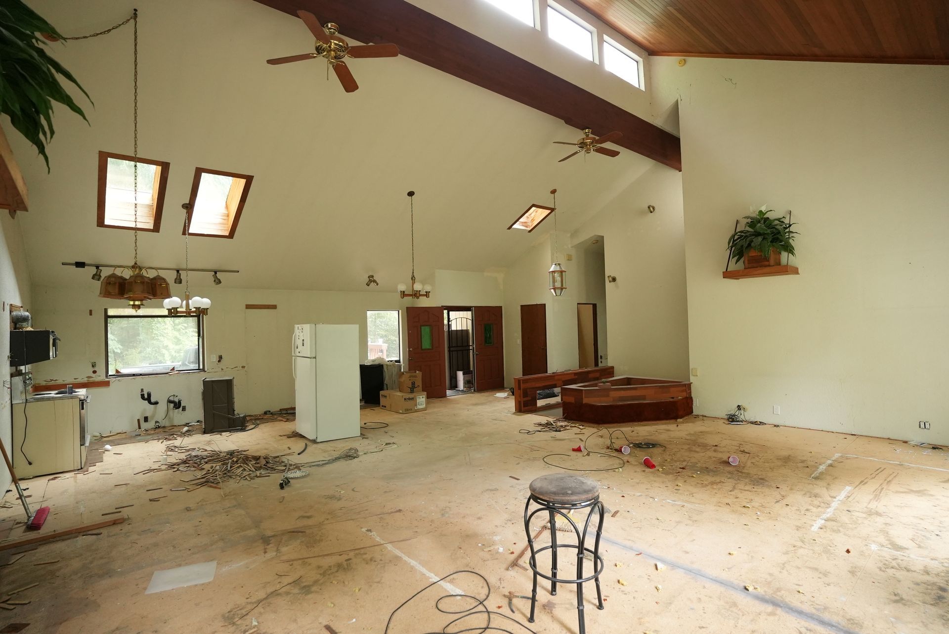 Empty church interior with debris on the floor, high ceiling, and scattered furniture.