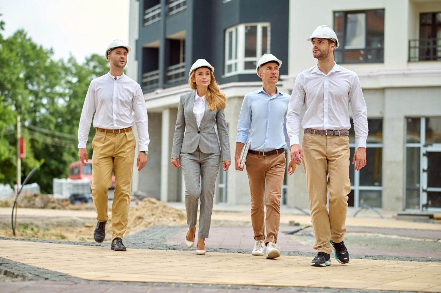 A group of people are walking in front of a building under construction.
