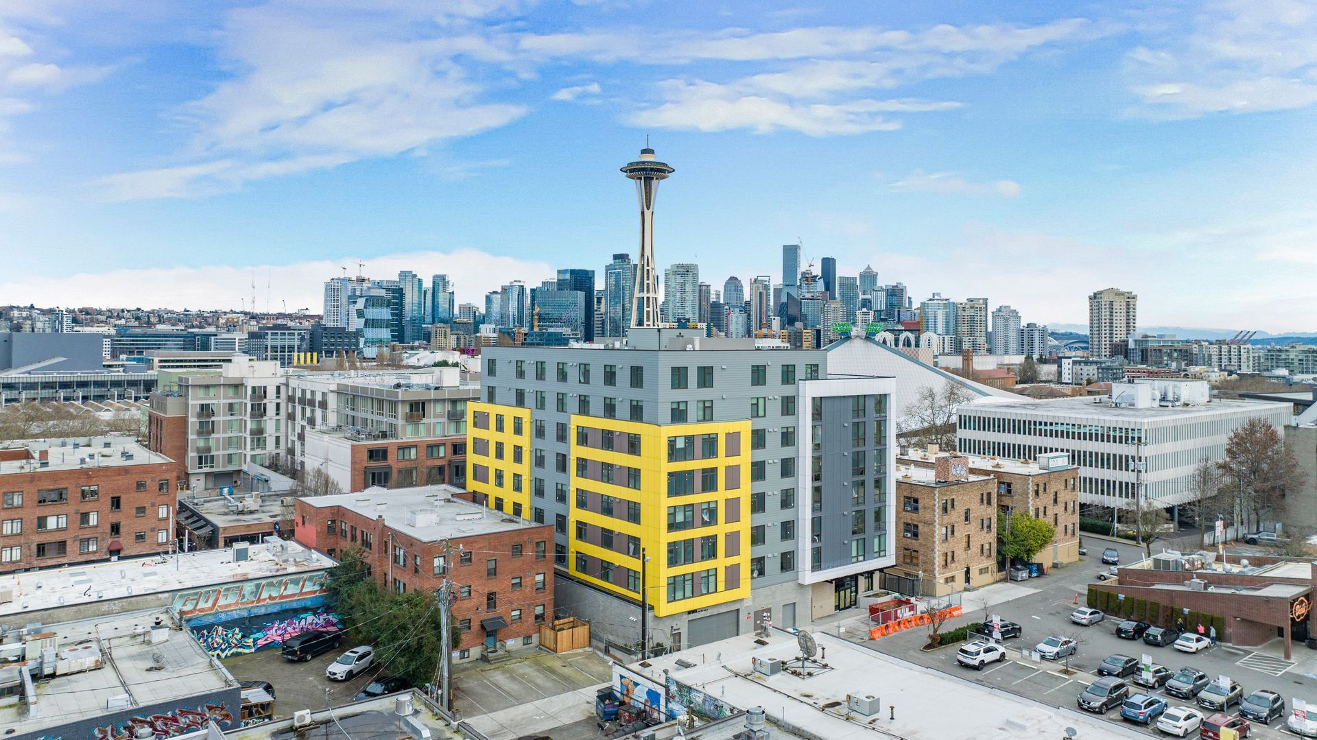 An aerial view of a city with a yellow building in the middle.