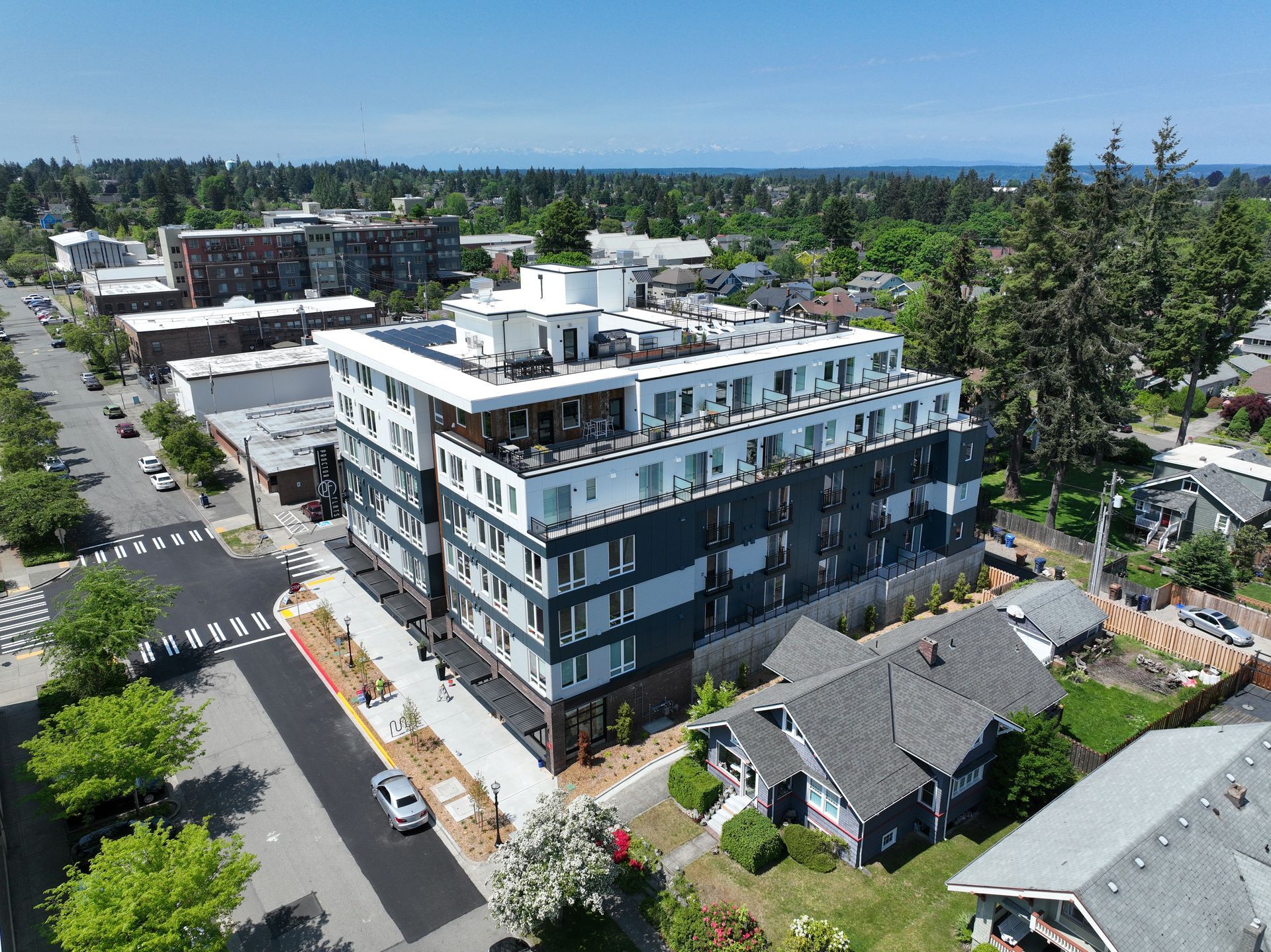 An aerial view of a large building in a city surrounded by houses and trees.
