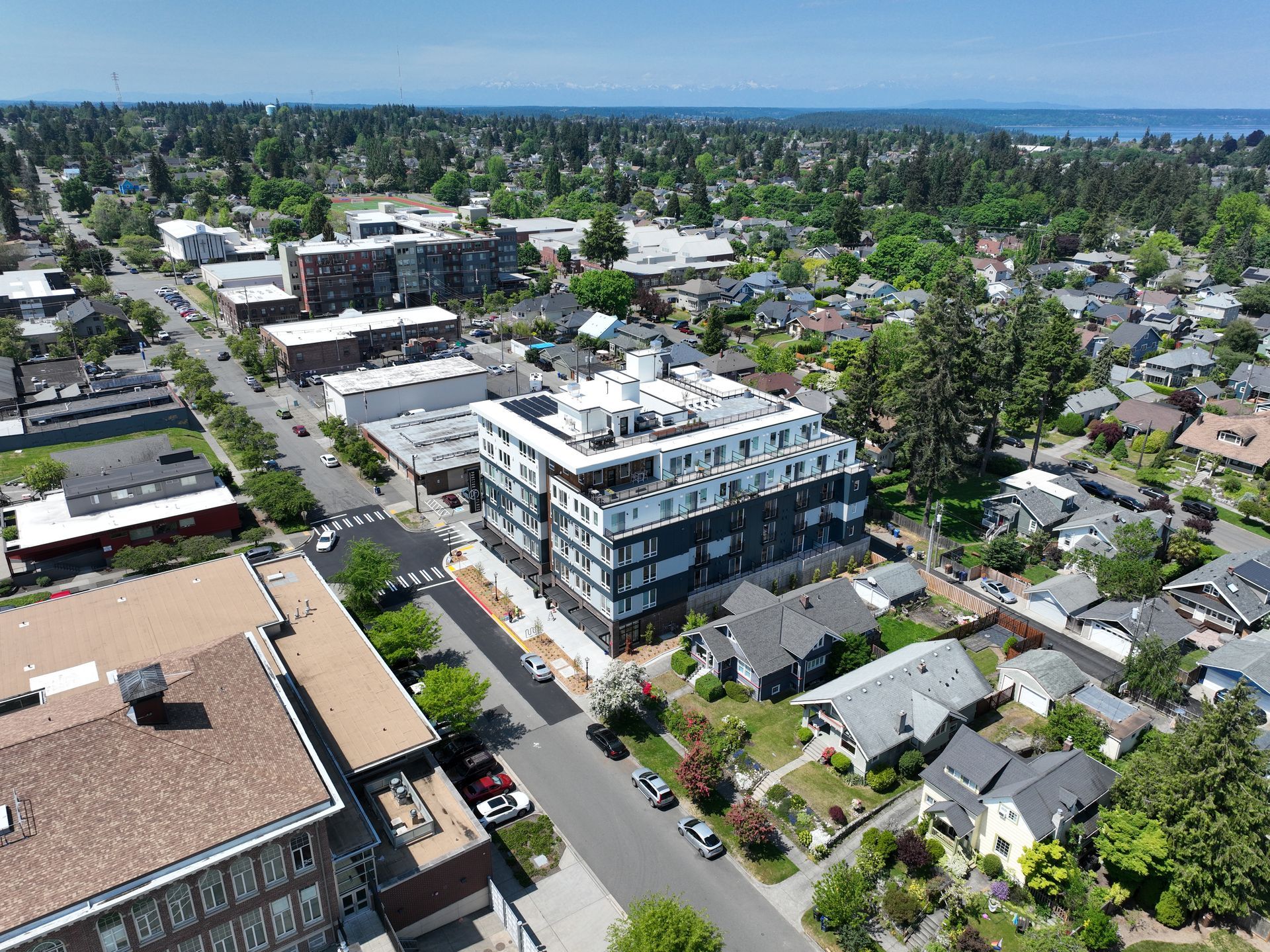 An aerial view of a city with a large building in the middle of it.