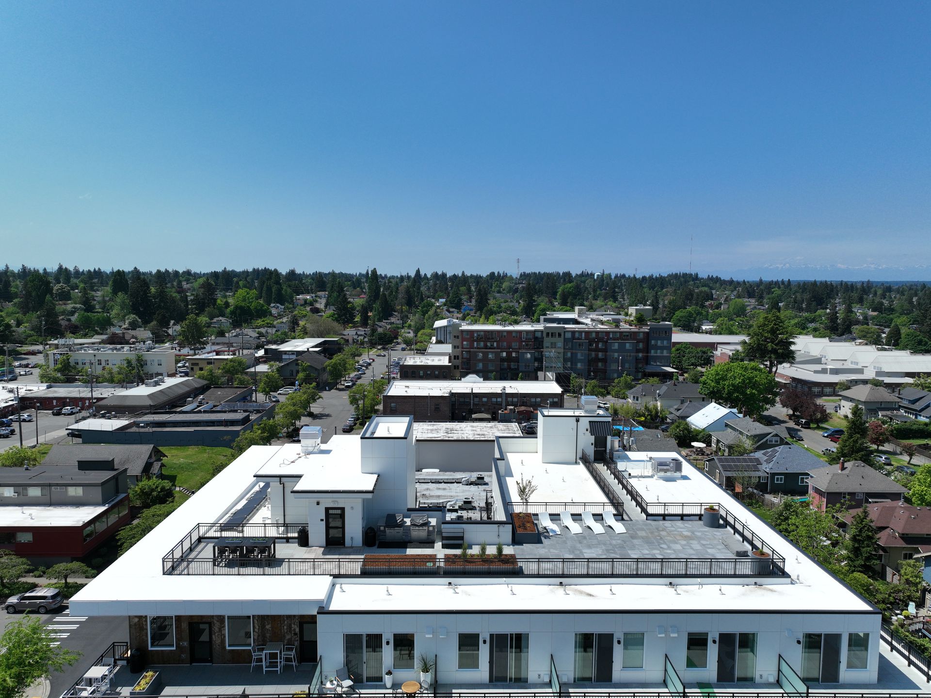 An aerial view of a large building with a white roof