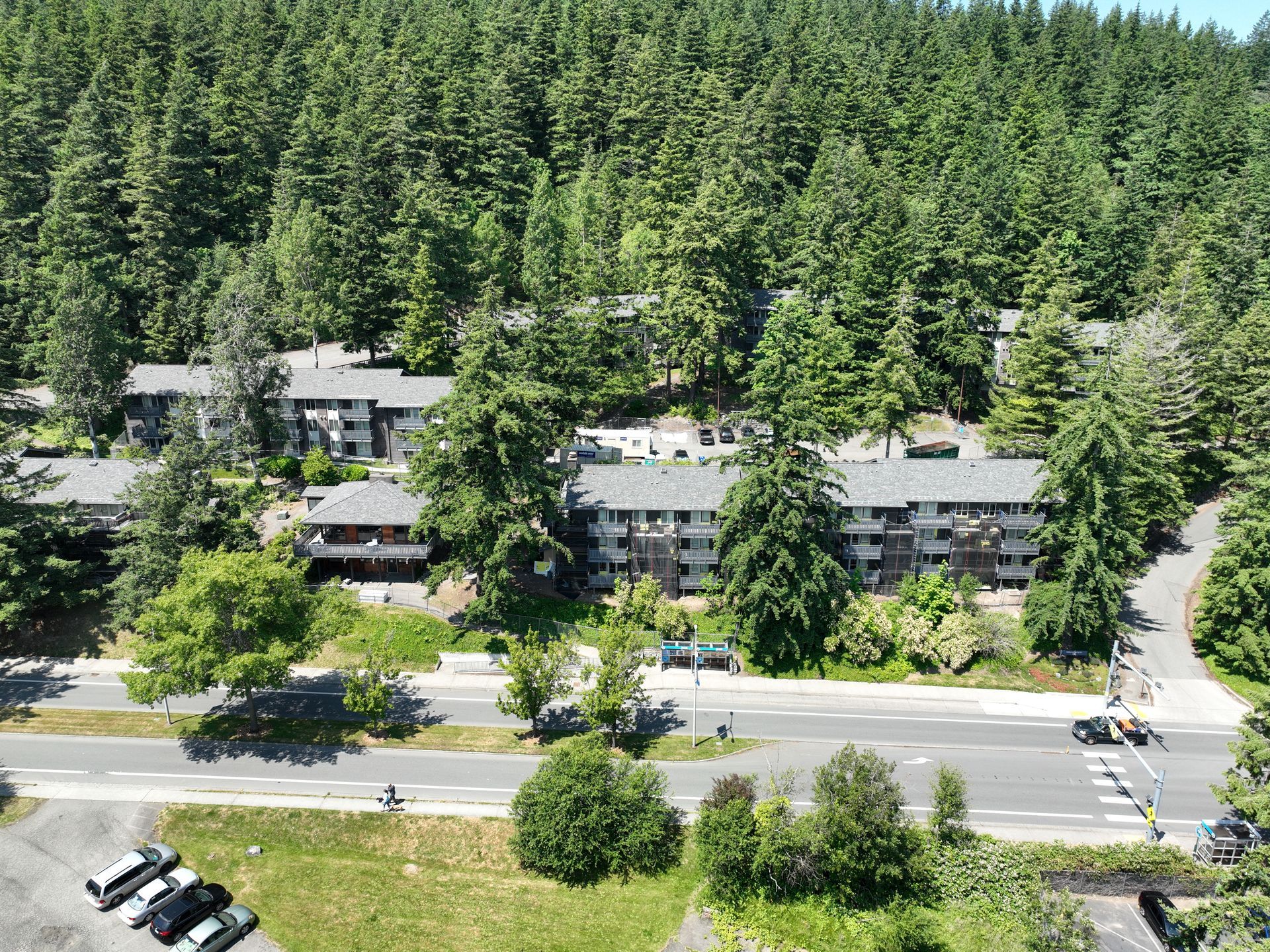 An aerial view of a building surrounded by trees and a parking lot.
