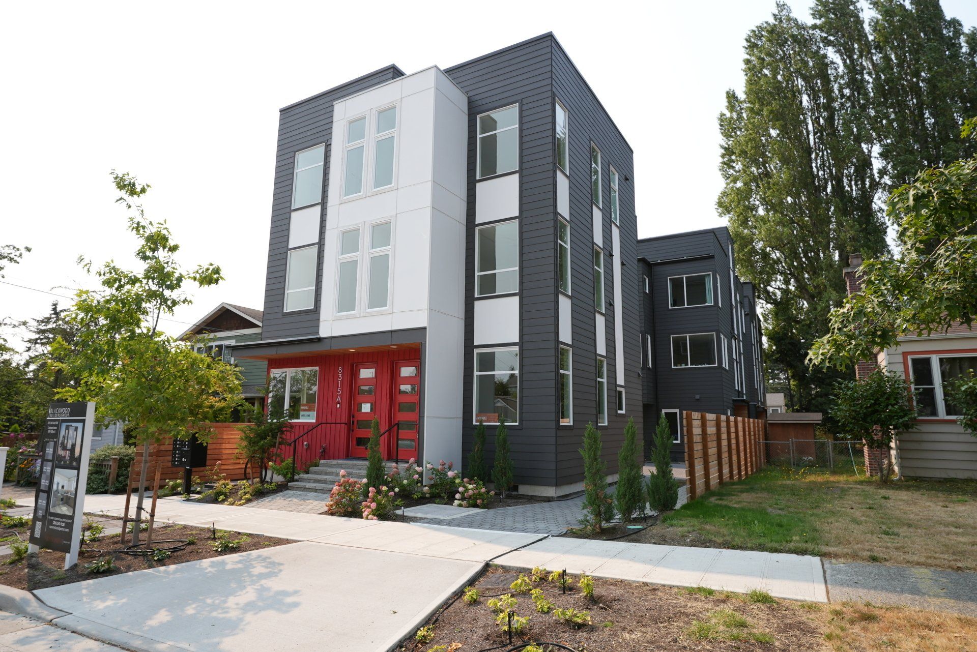 A large black and white building with a red door