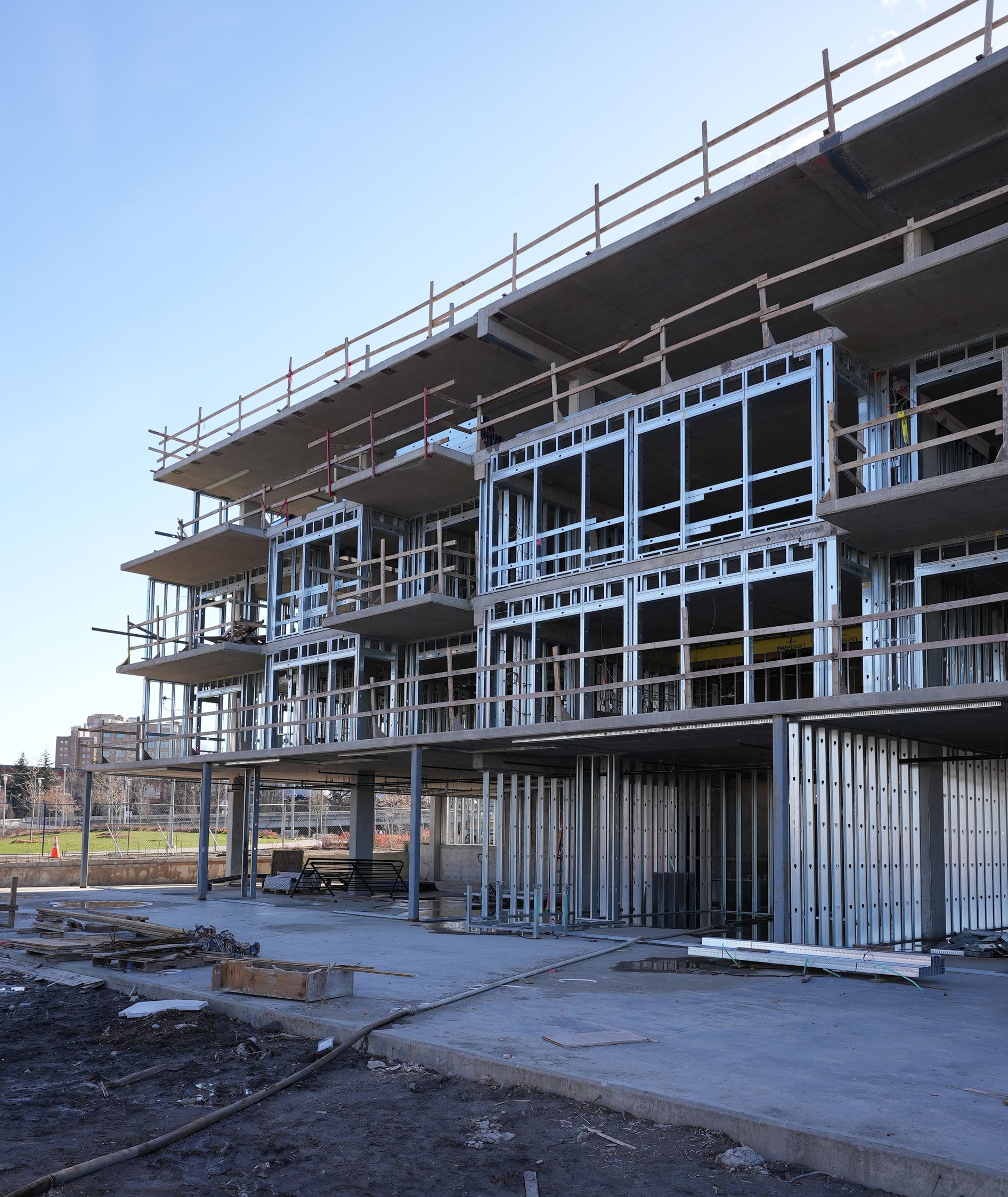 Unfinished multi-story building with exposed steel framing at a construction site.