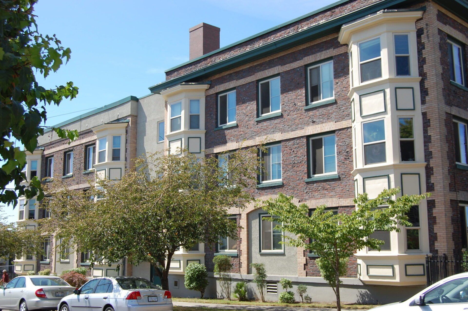 A building with a lot of windows and cars parked in front of it
