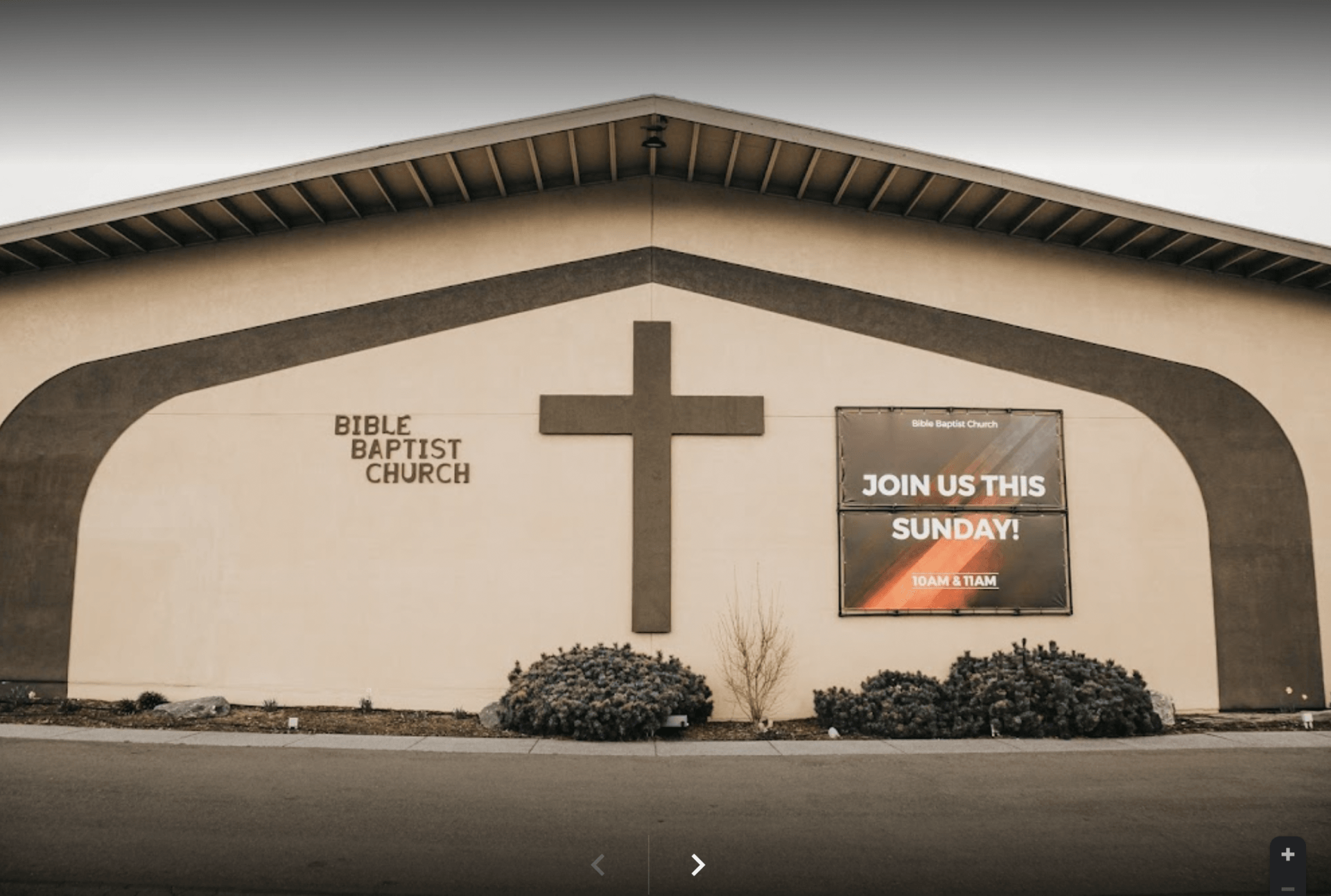 The front of a bible baptist church with a cross on it.
