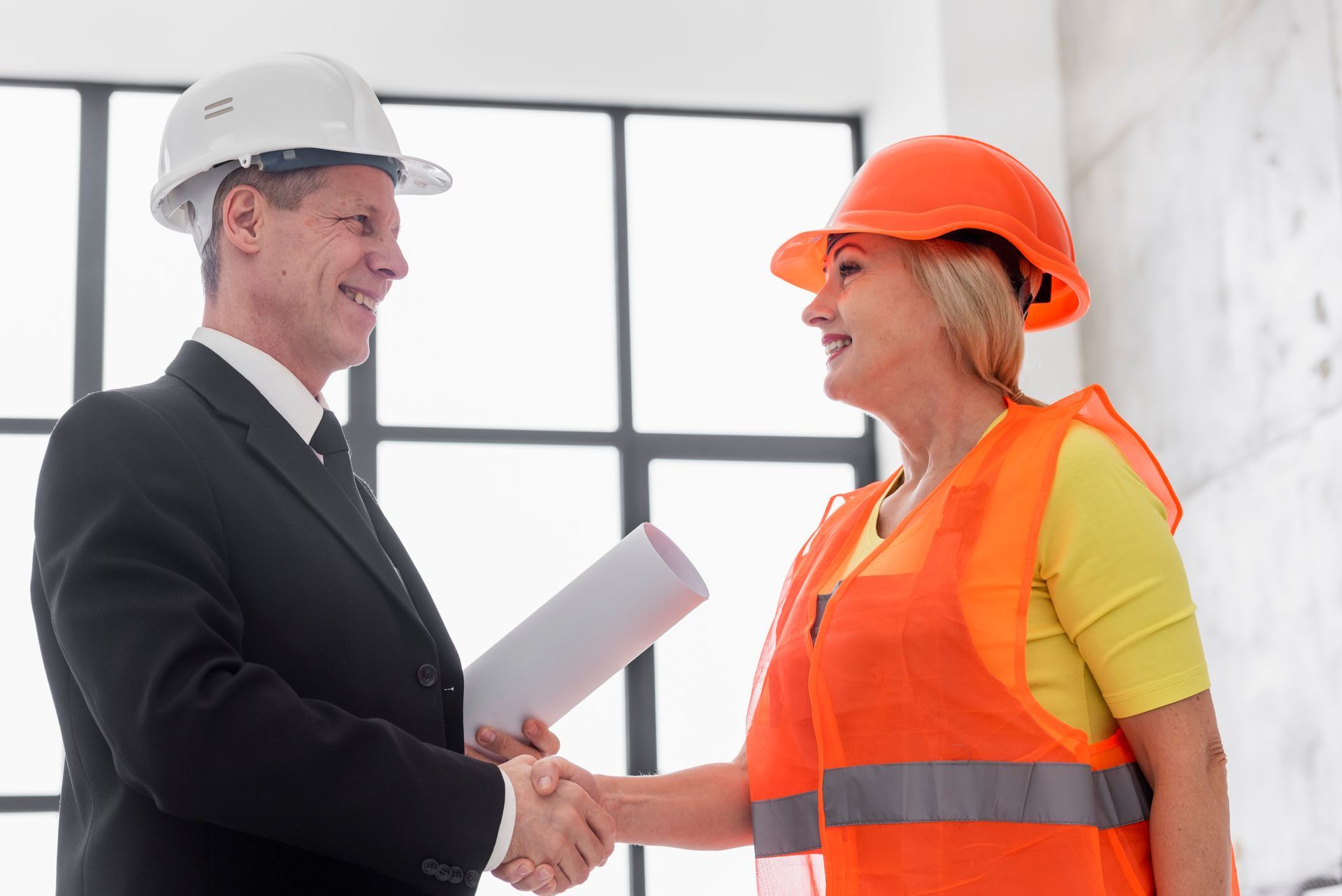 A man and a woman are shaking hands in a room.