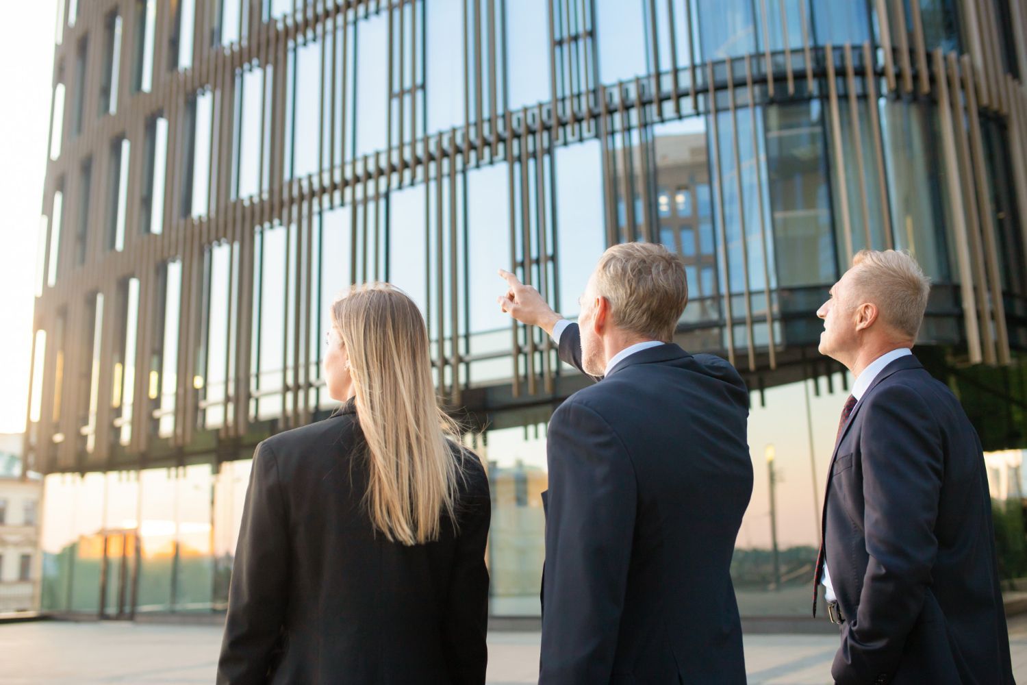 A group of business people are looking at a building.