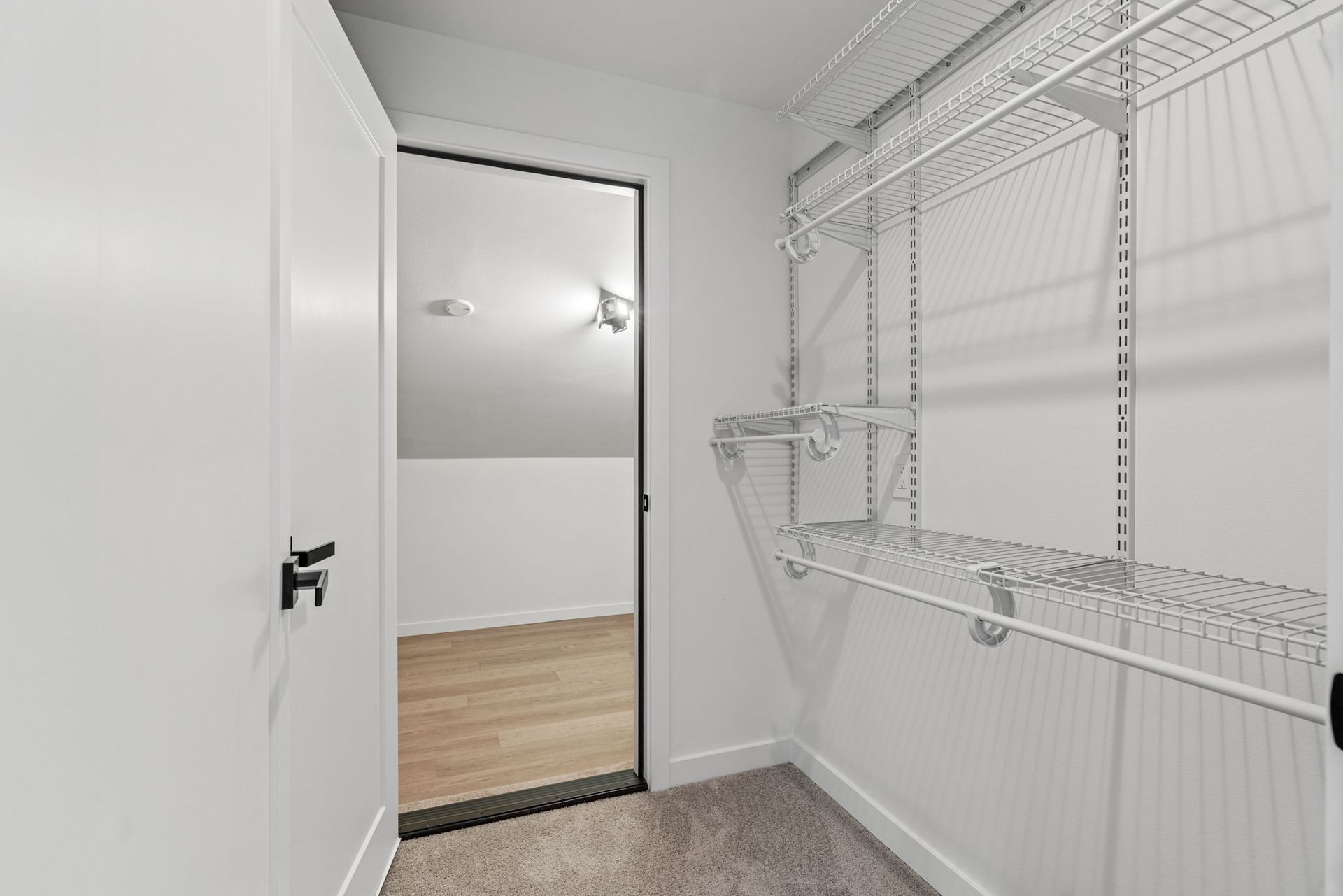 A walk in closet with a sliding glass door and shelves.