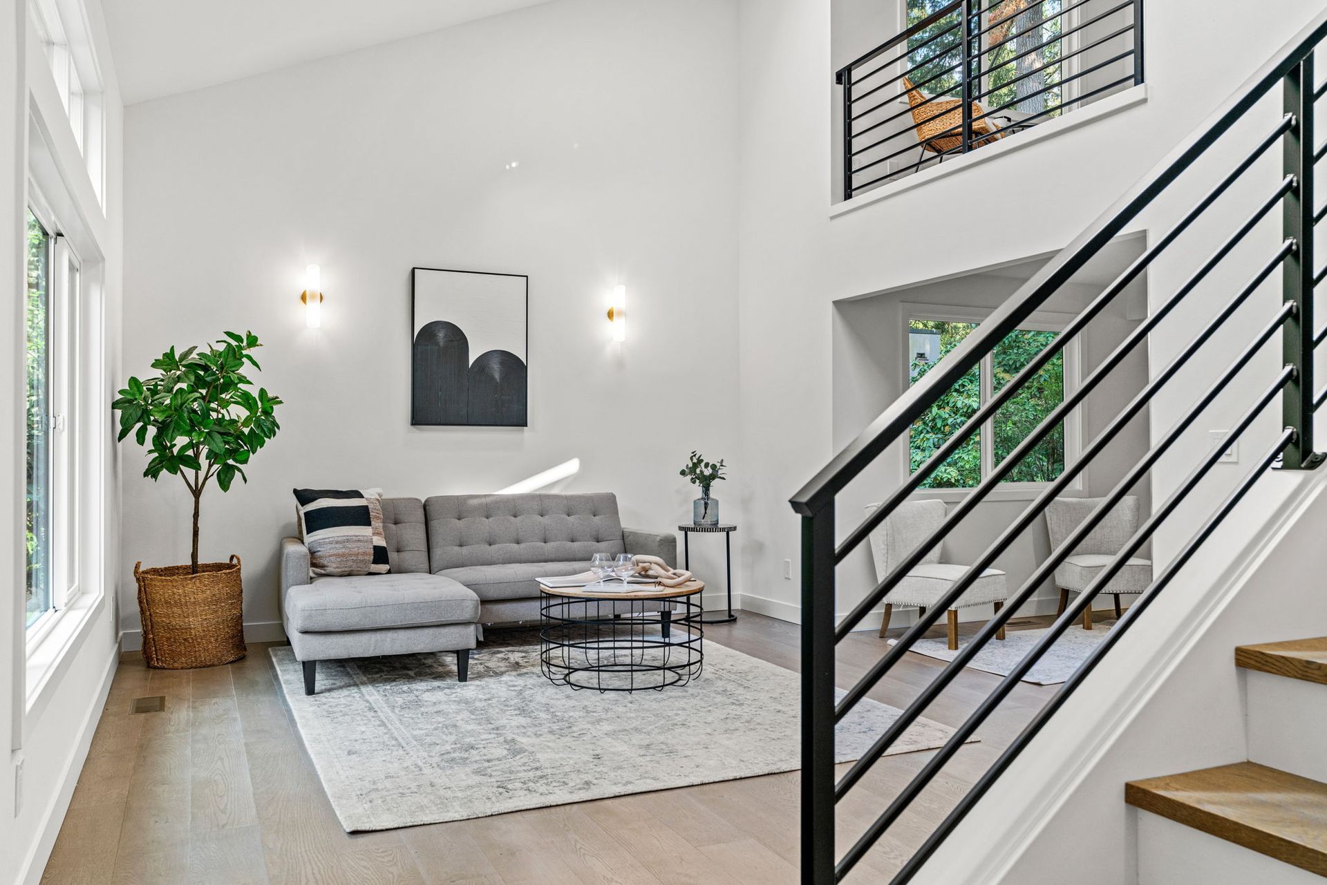 A living room with a couch , table , chairs and stairs.