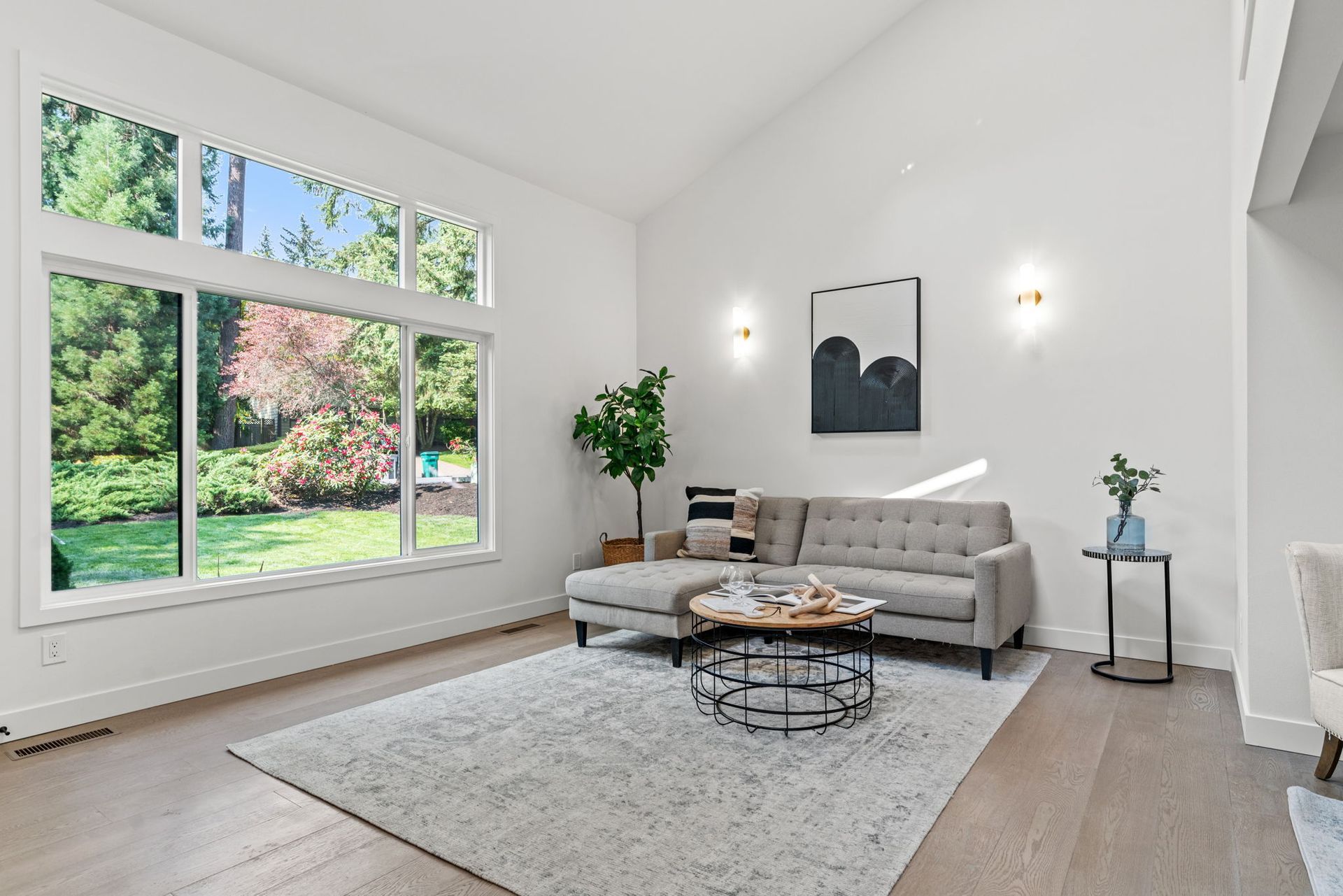 A living room with a couch , coffee table , and large windows.