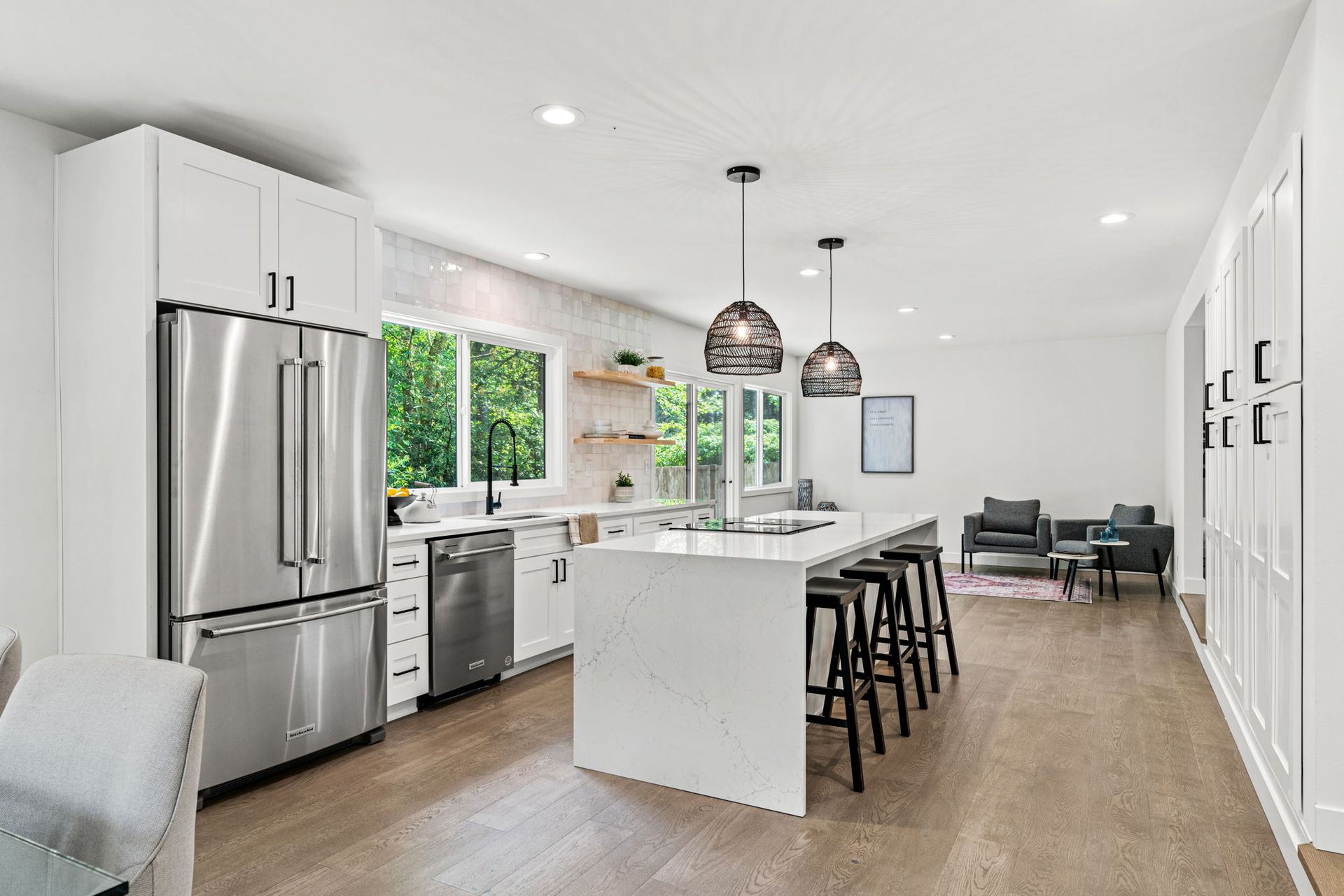 A kitchen with stainless steel appliances and a large island in the middle.