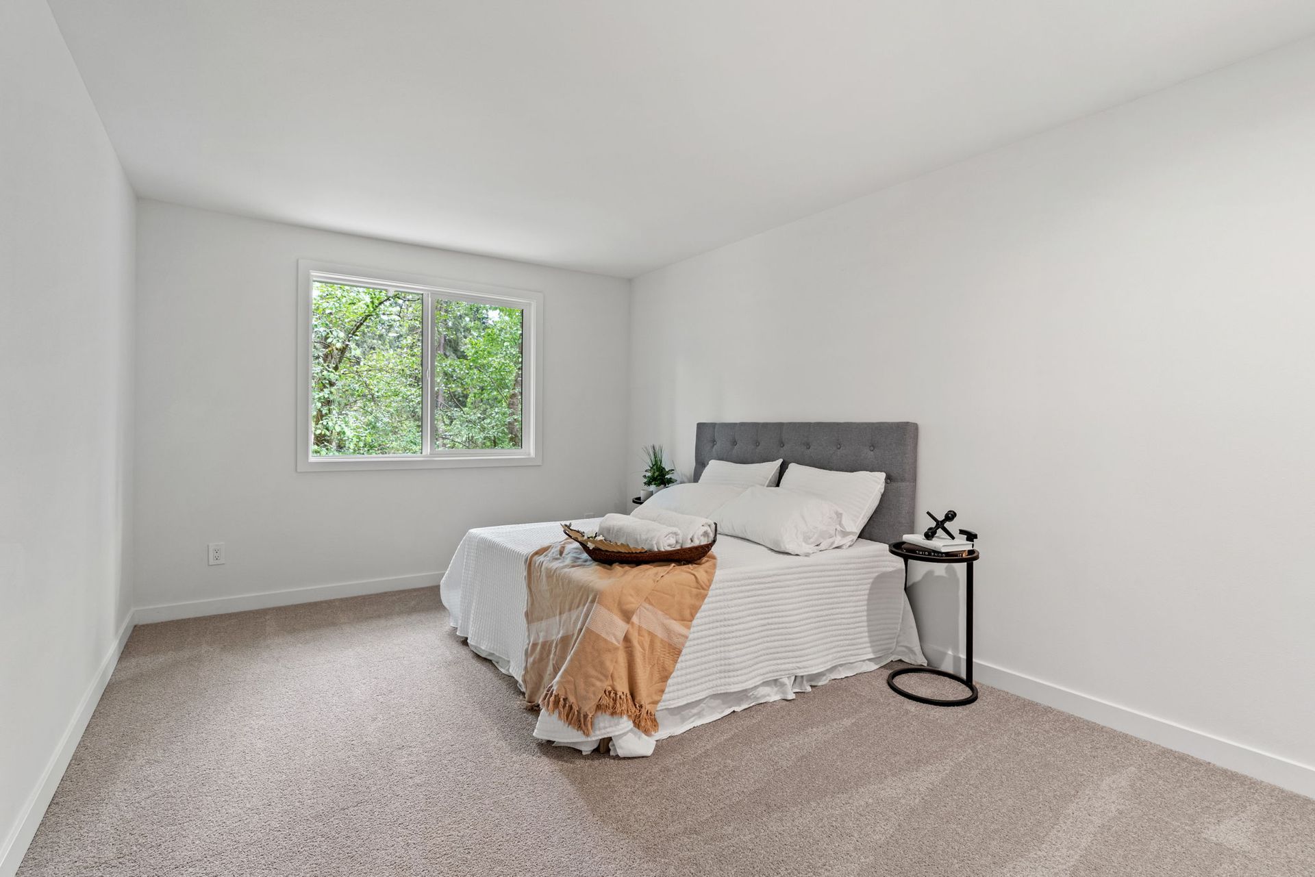 A bedroom with a bed , nightstand , and window.
