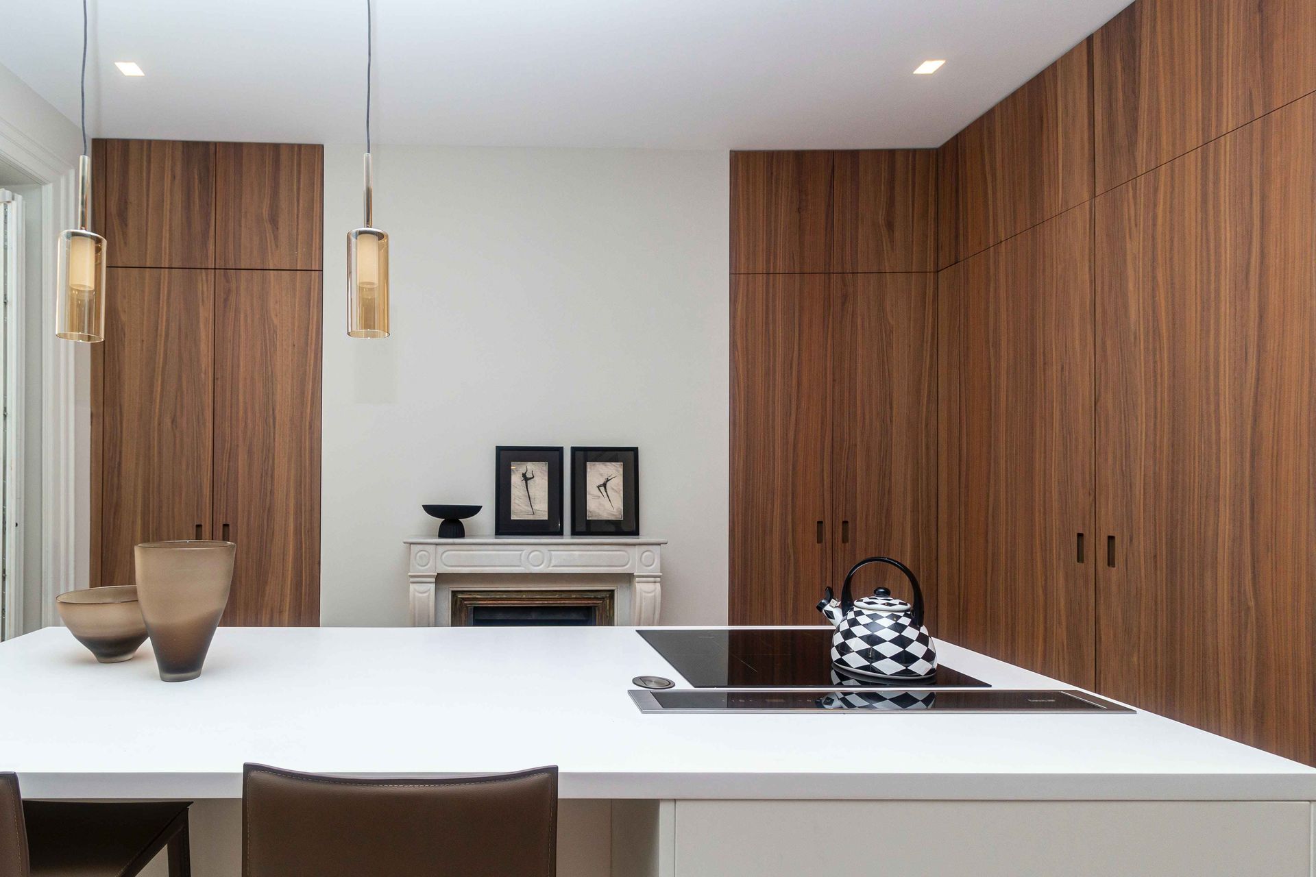 Modern minimalist kitchen with white island, wood cabinets, and pendant lights