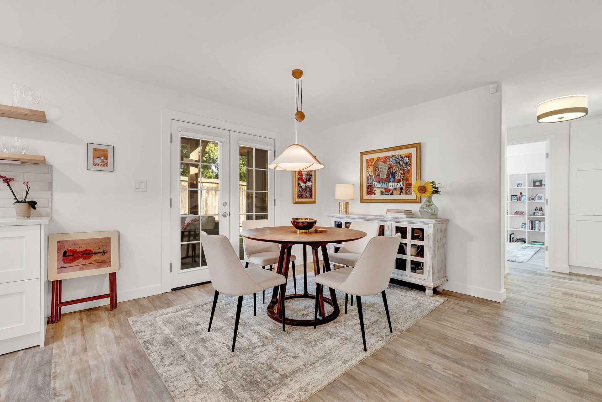 A dining room with a table and chairs and a rug.