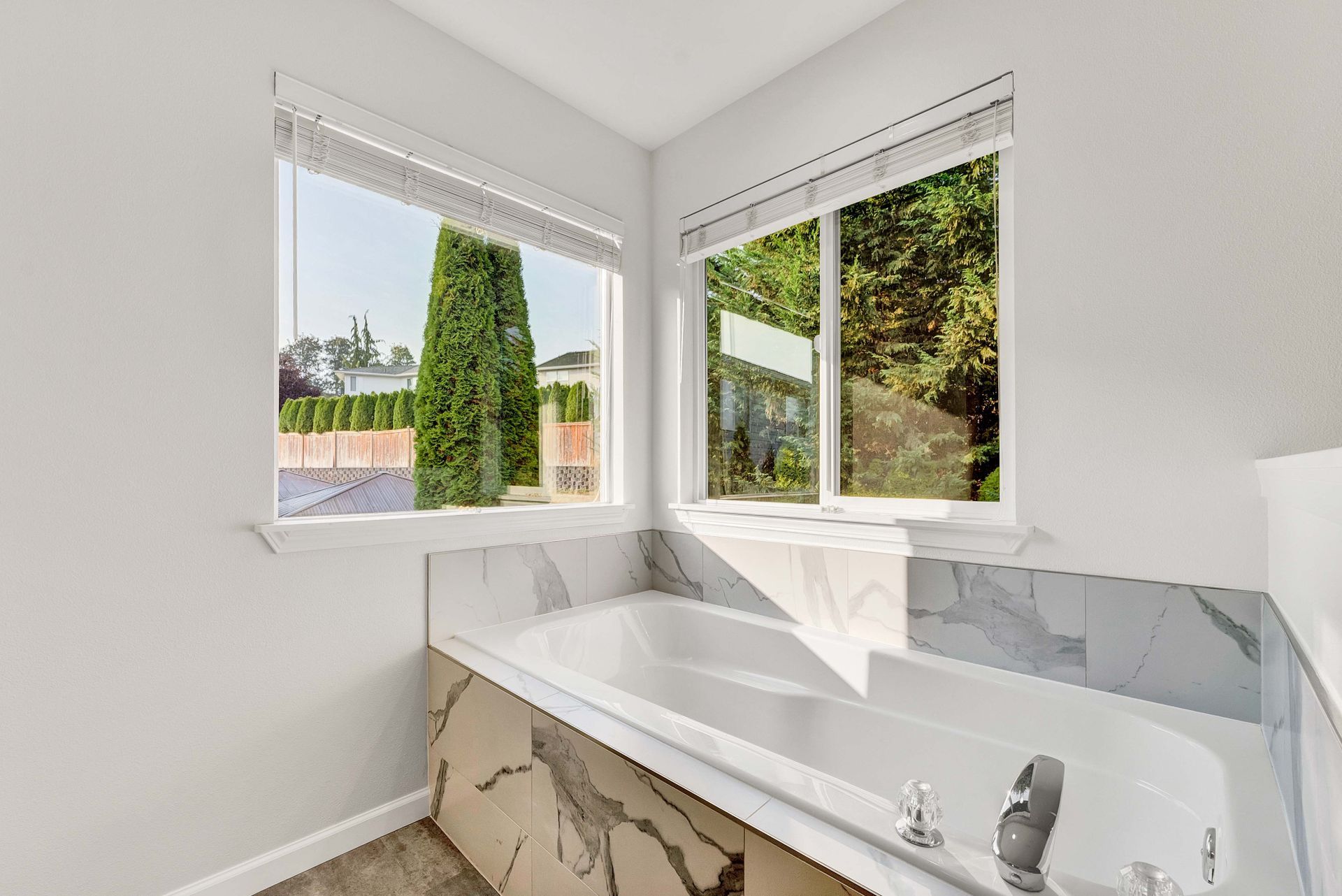A bathroom with a bathtub and a window.