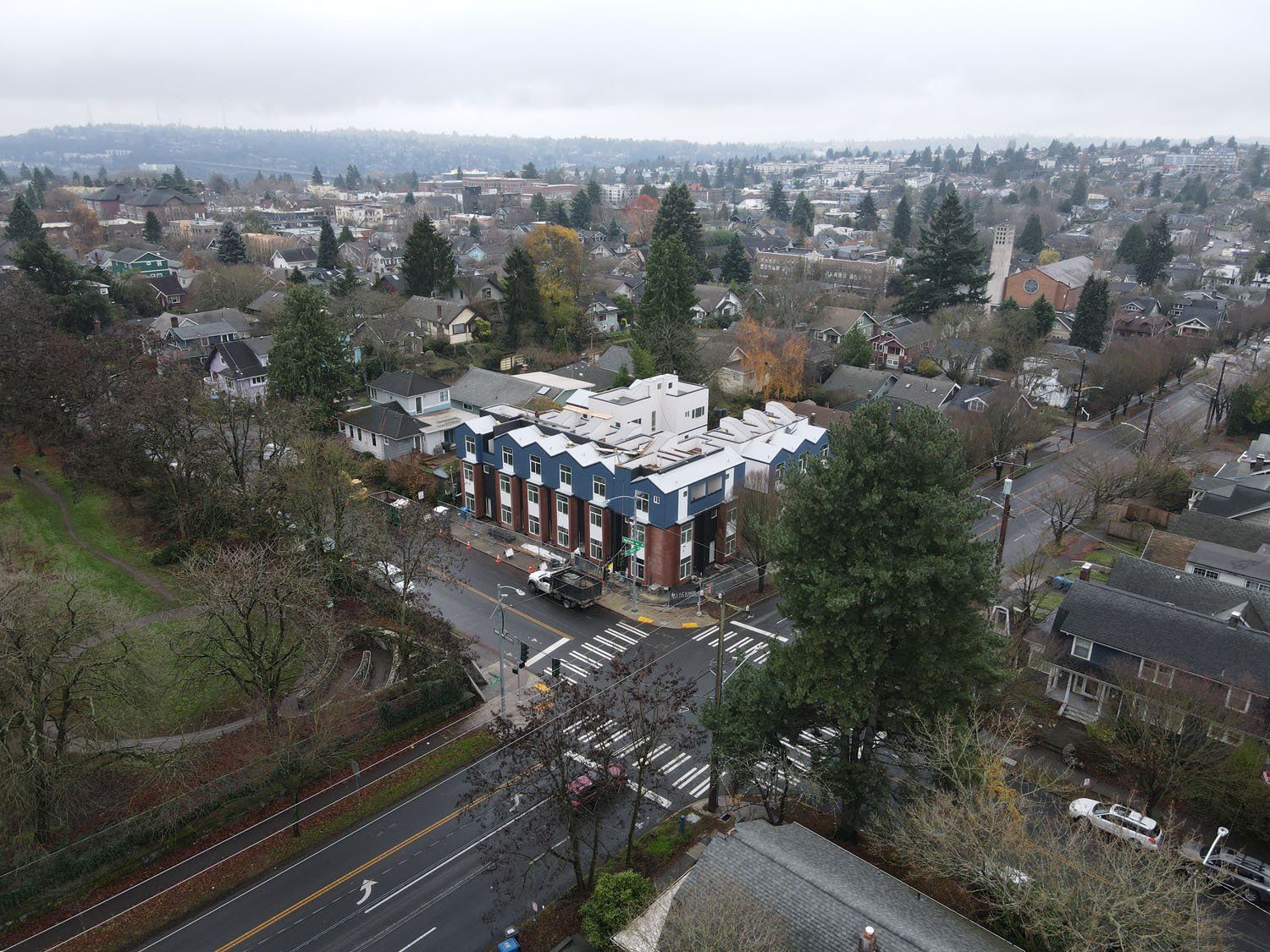 An aerial view of a city with a building in the middle of it.