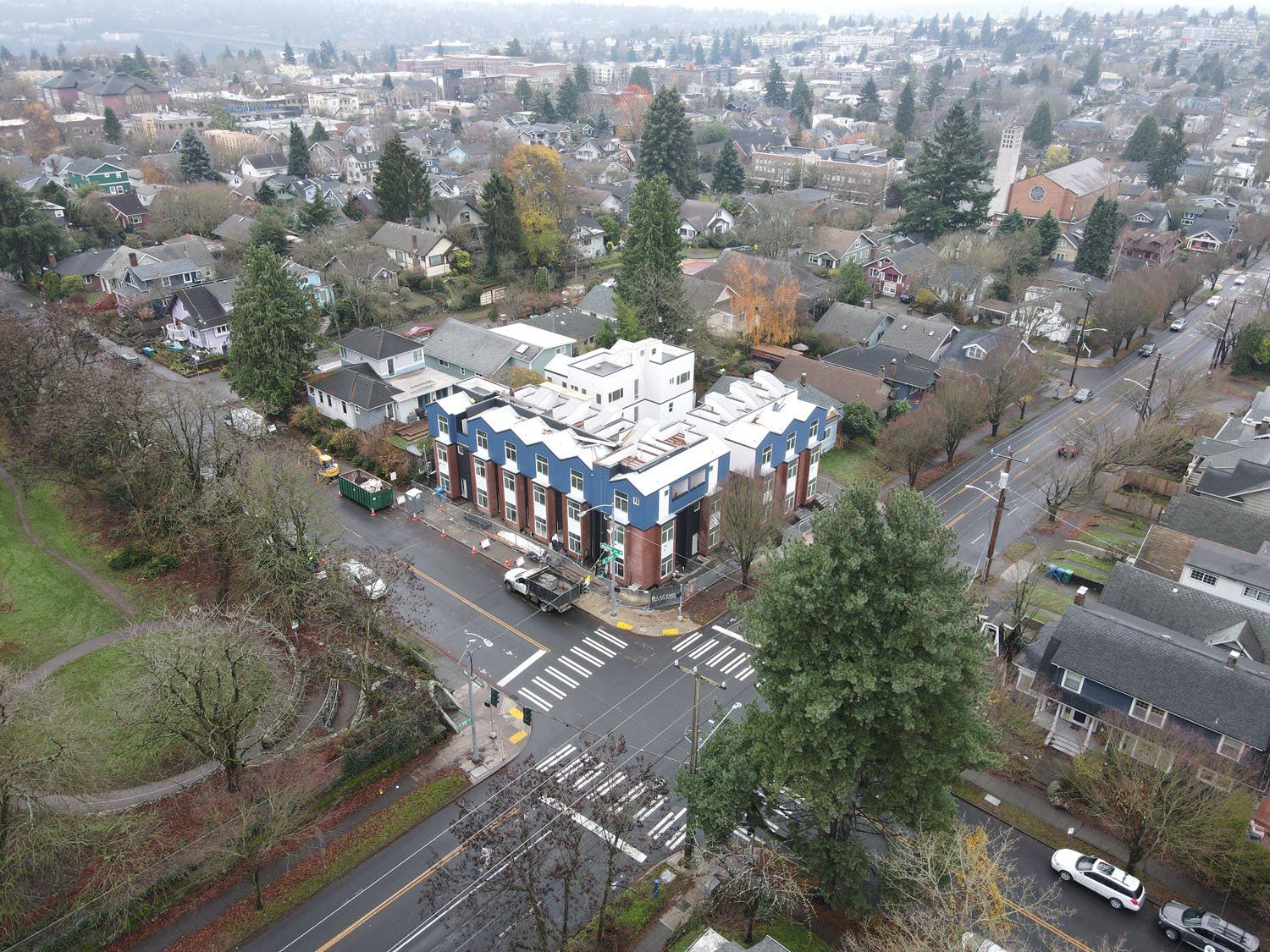An aerial view of a residential area with a large building in the middle of the street.