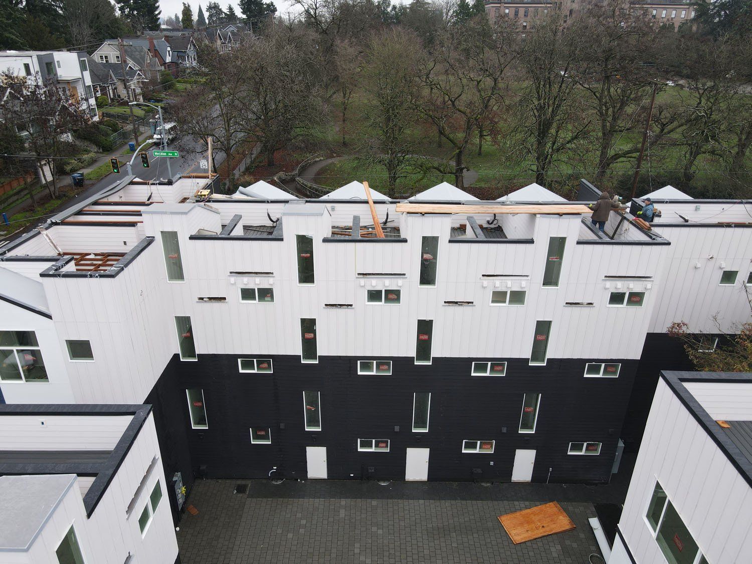 An aerial view of a building under construction with trees in the background