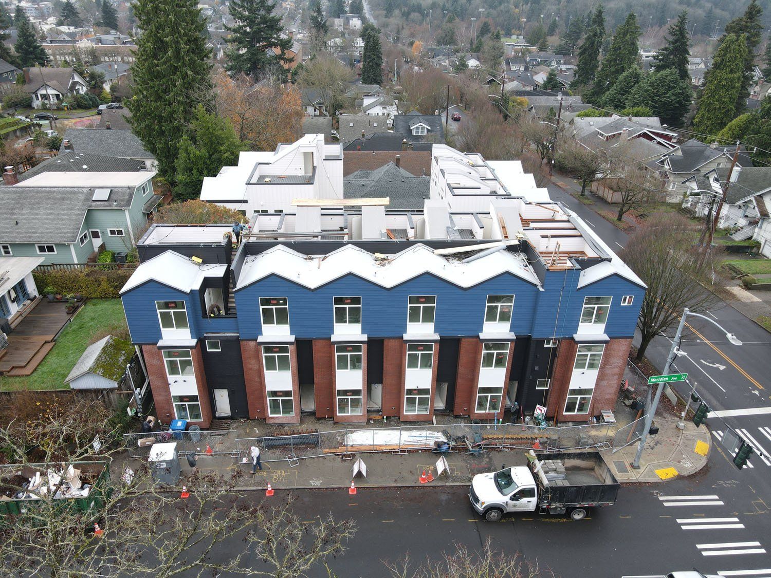 An aerial view of a building under construction with a truck parked in front of it