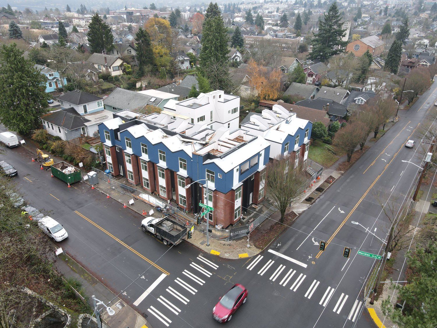 An aerial view of an intersection with a building in the background