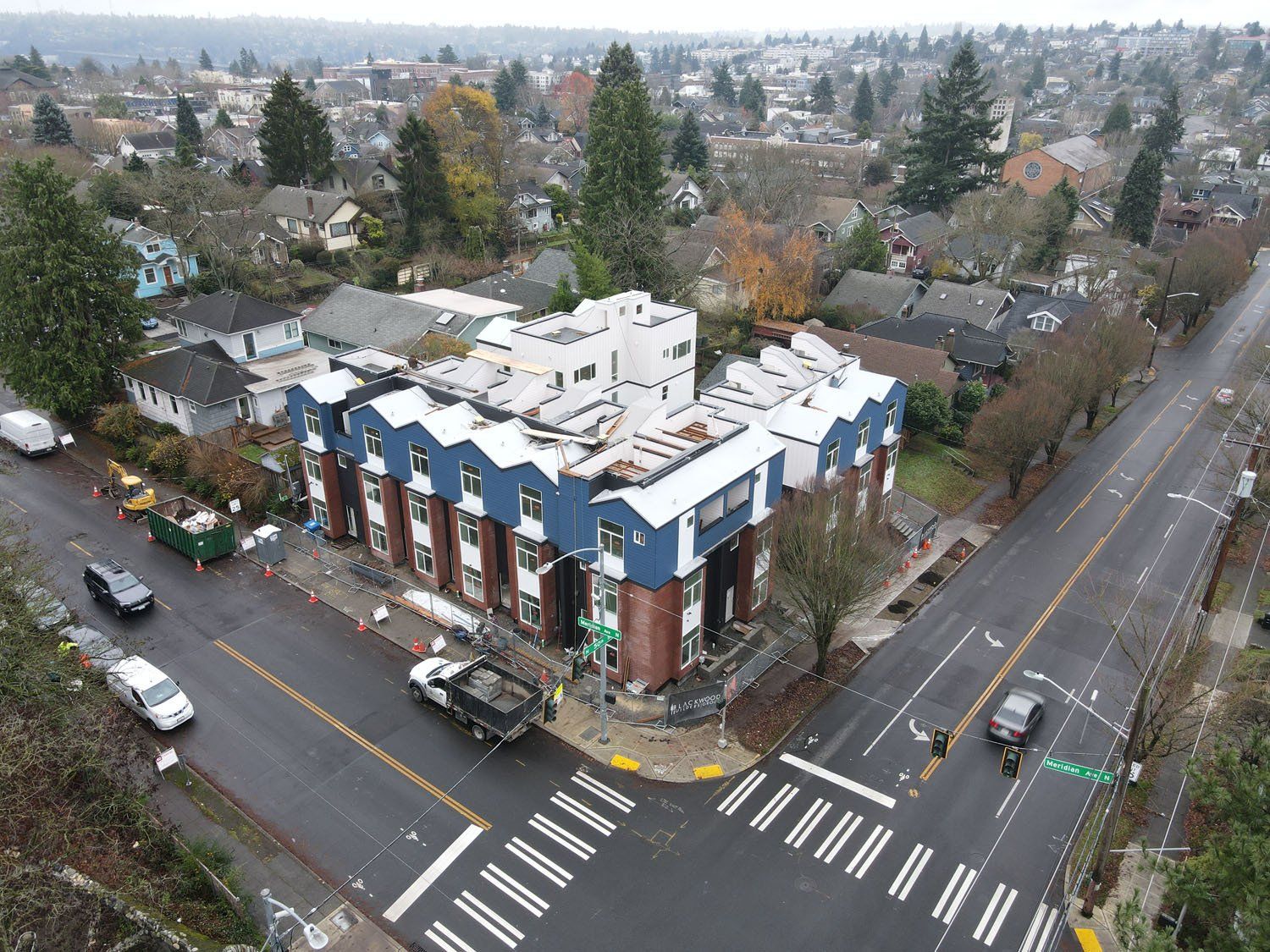 An aerial view of a building under construction on the corner of a city street.