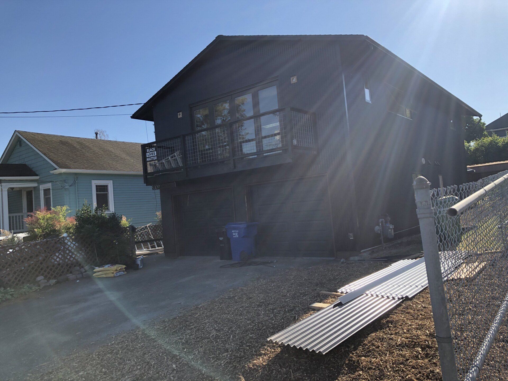 A black house with a blue house in the background