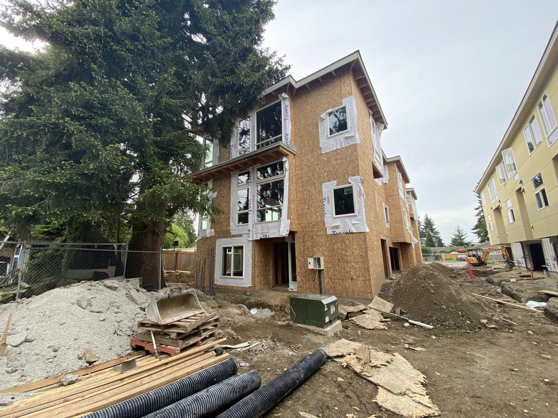 A building under construction with a tree in the background.