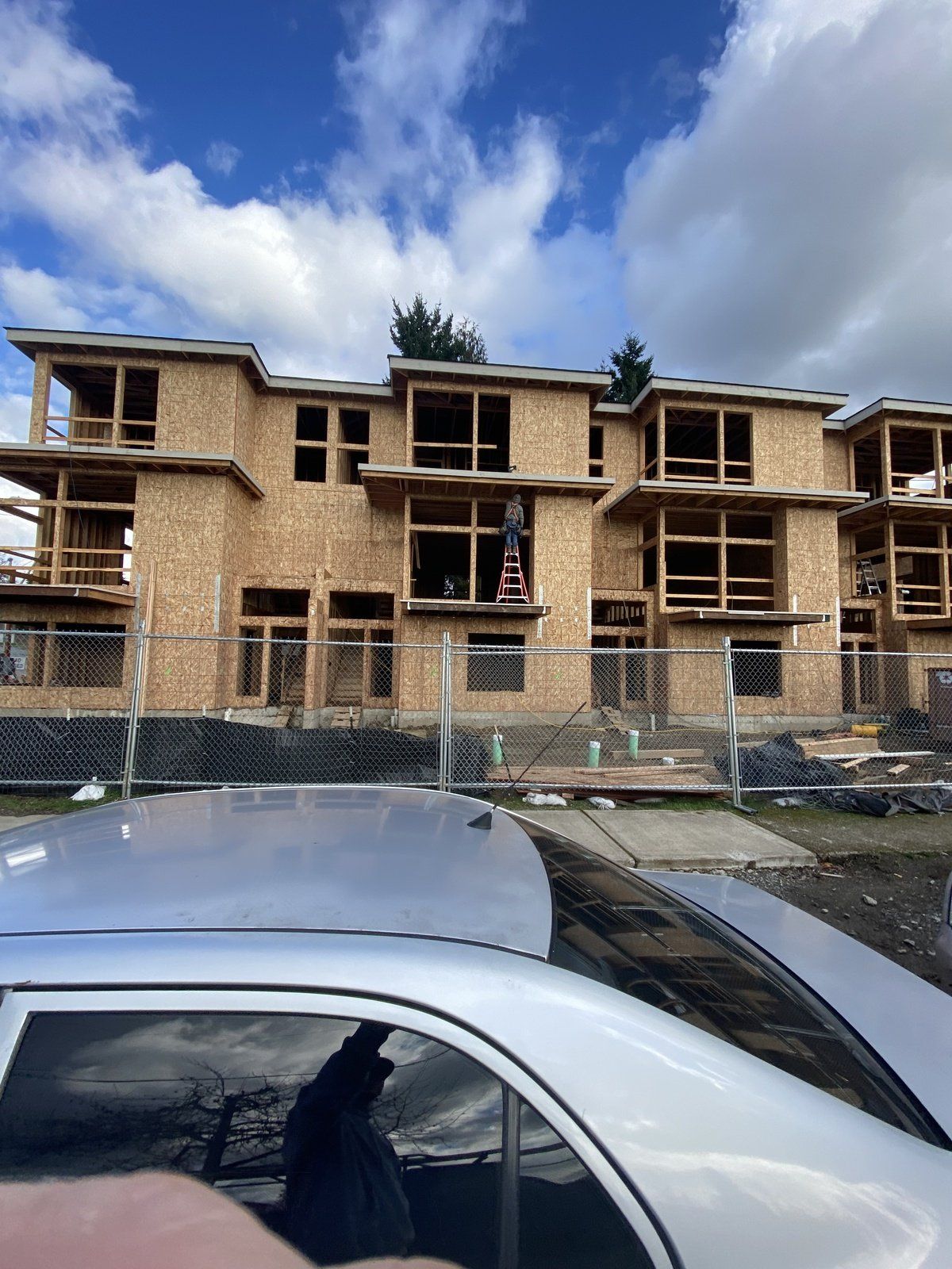 A car is parked in front of a building under construction