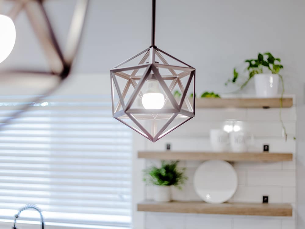 A pendant light is hanging from the ceiling in a kitchen.