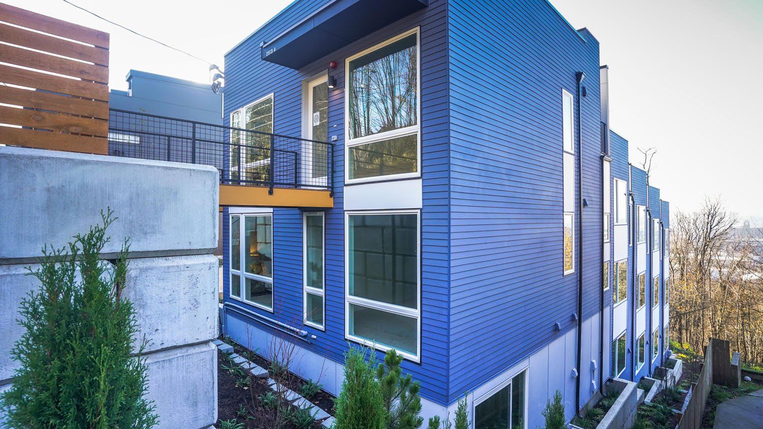 A blue building with a lot of windows and a balcony.