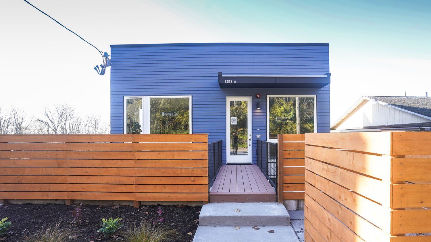 A blue house with a wooden fence around it