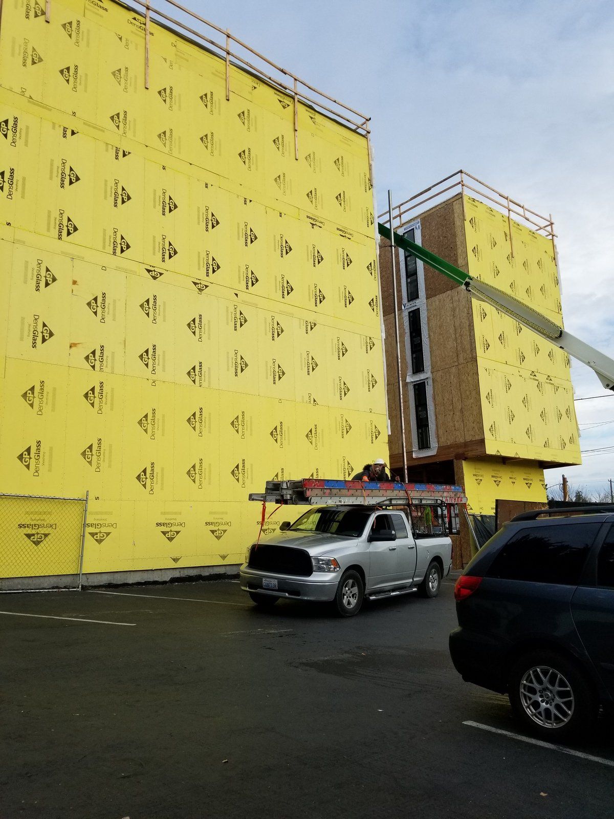 A truck is parked in front of a building under construction.