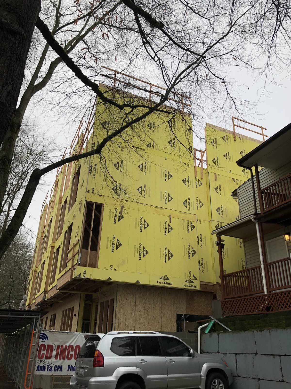 A building under construction with a car parked in front of it.