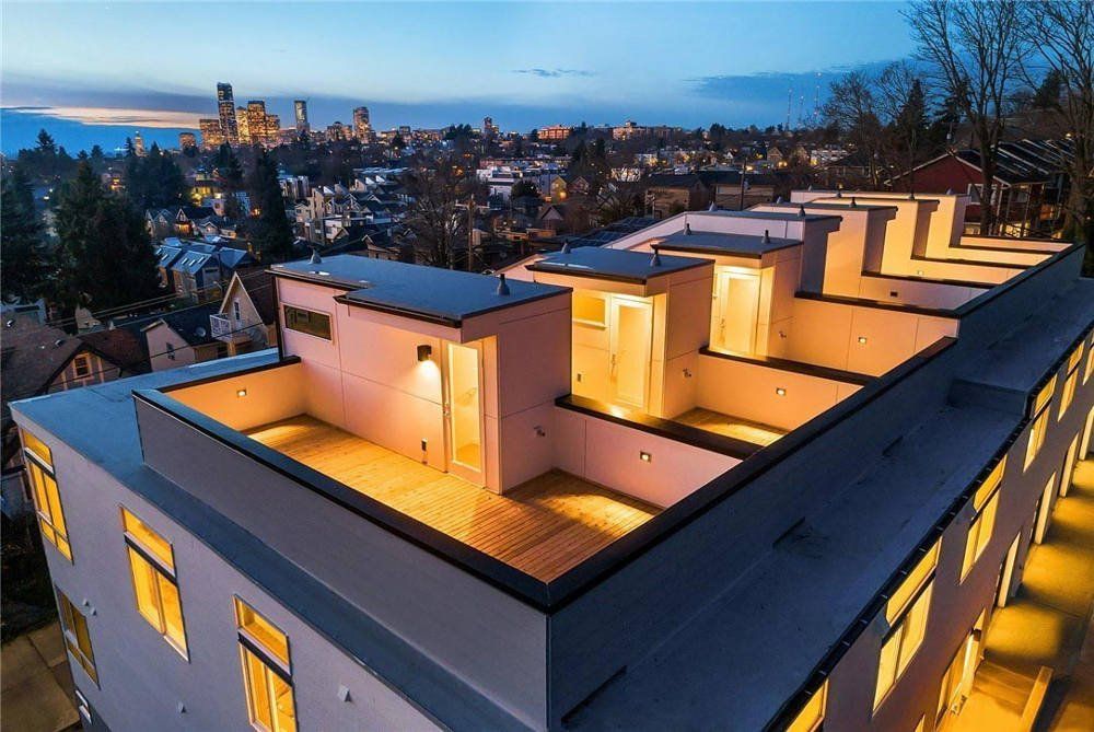 An aerial view of a building at night with a city in the background