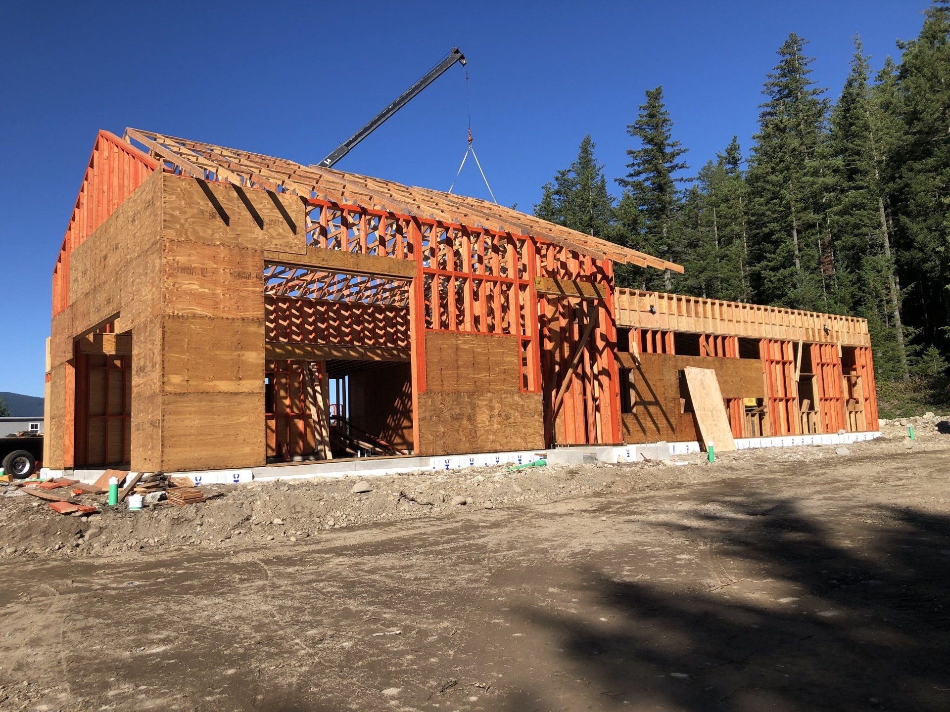 A large wooden building is being built with a crane in the background.