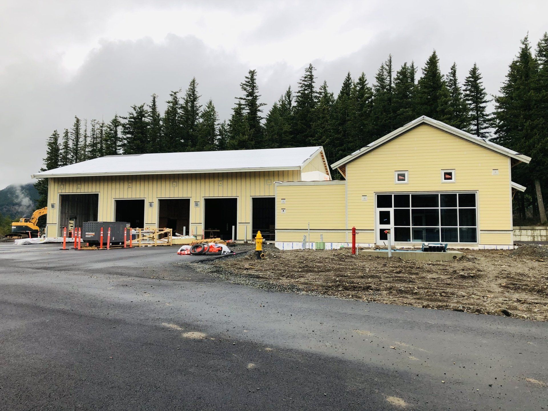 A yellow building with a white roof is under construction