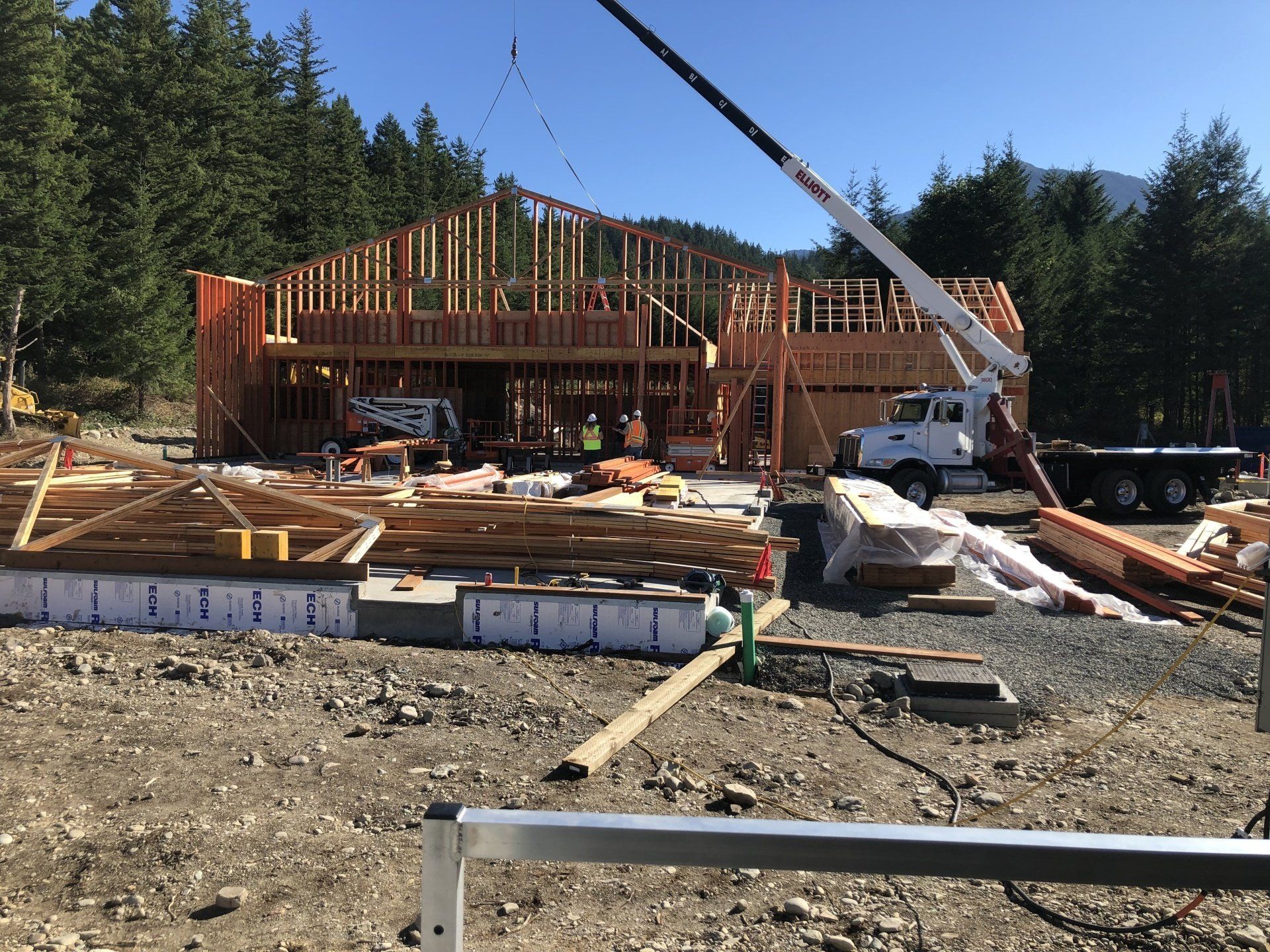 A large house is being built with a crane in the background.