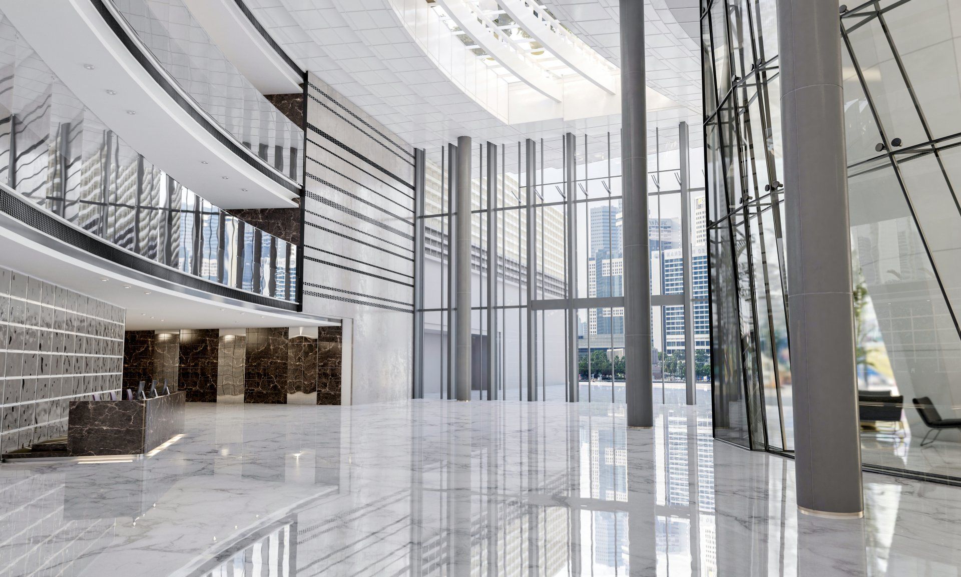 A large empty lobby of a building with a lot of windows.