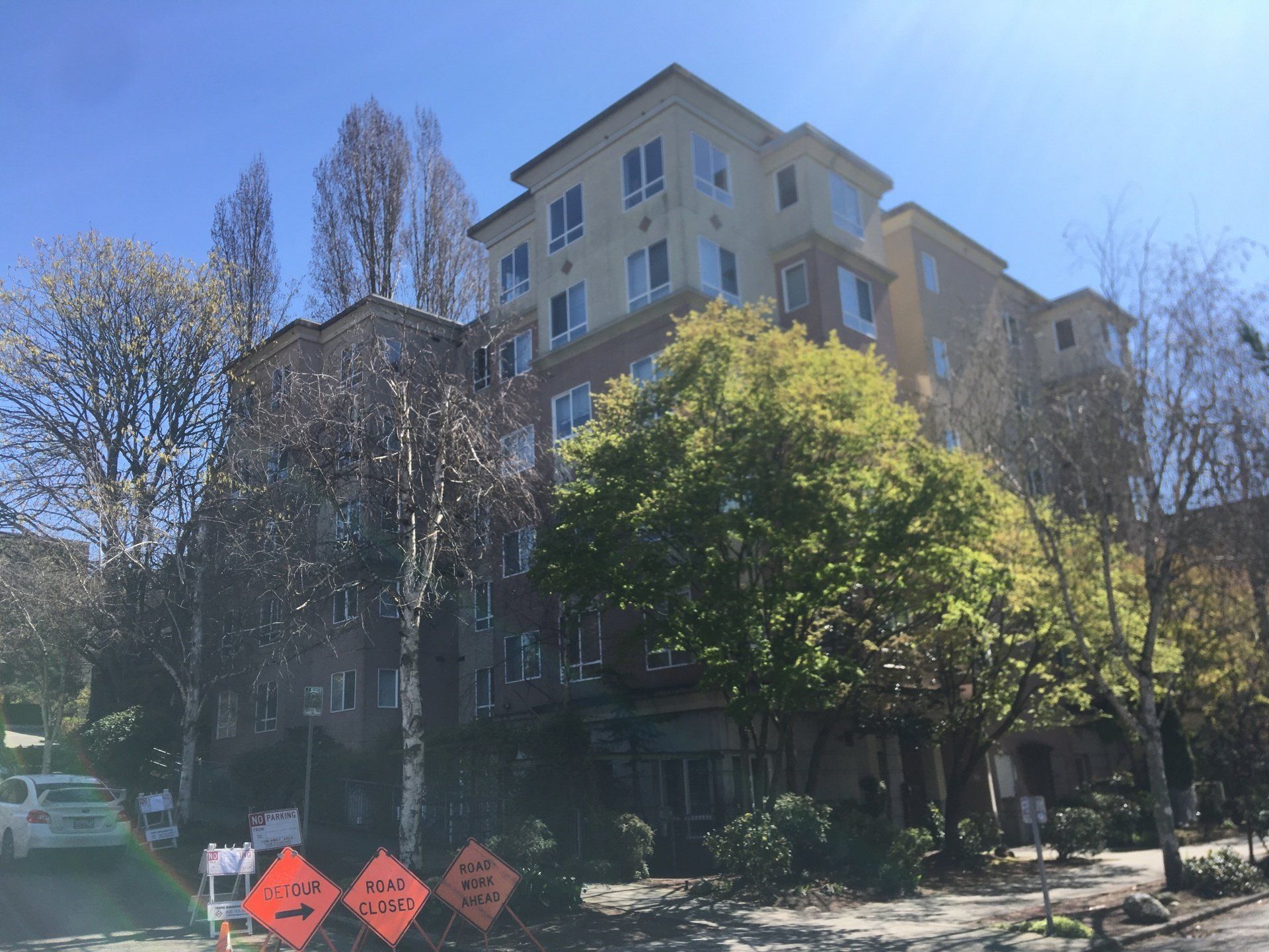 A large apartment building with a lot of windows and trees in front of it.