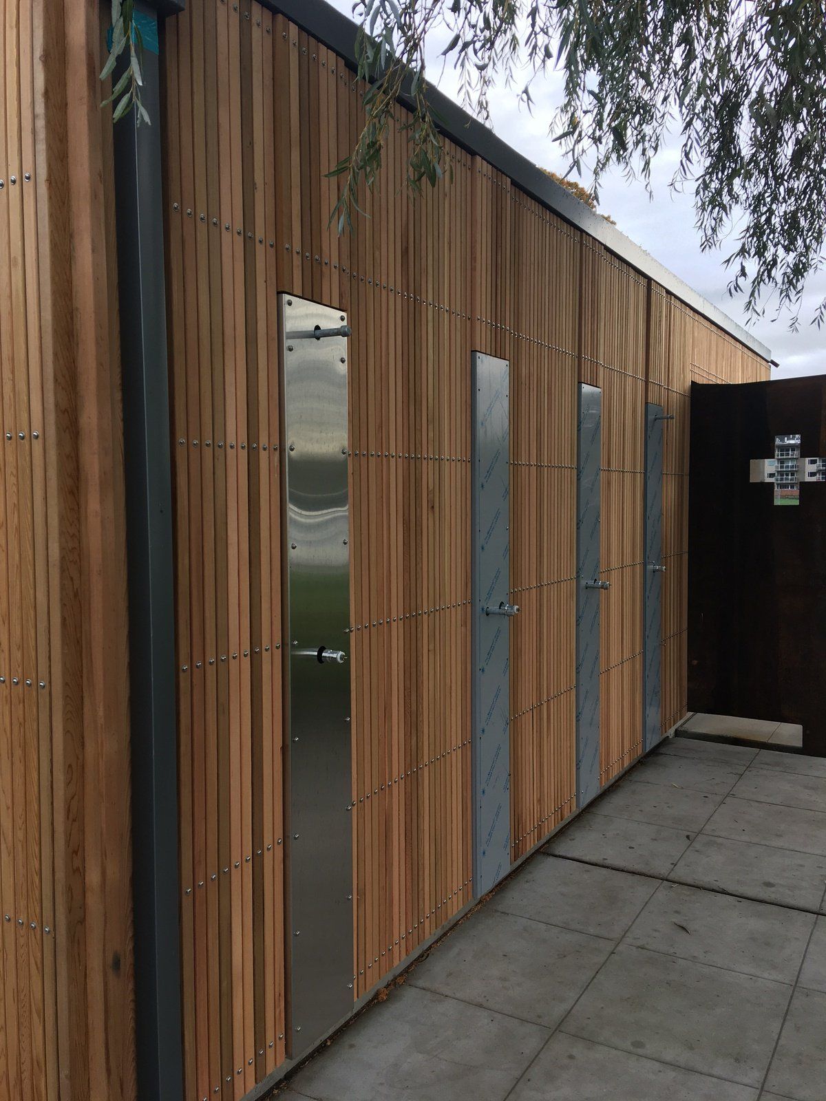 A building with wooden siding and stainless steel doors.