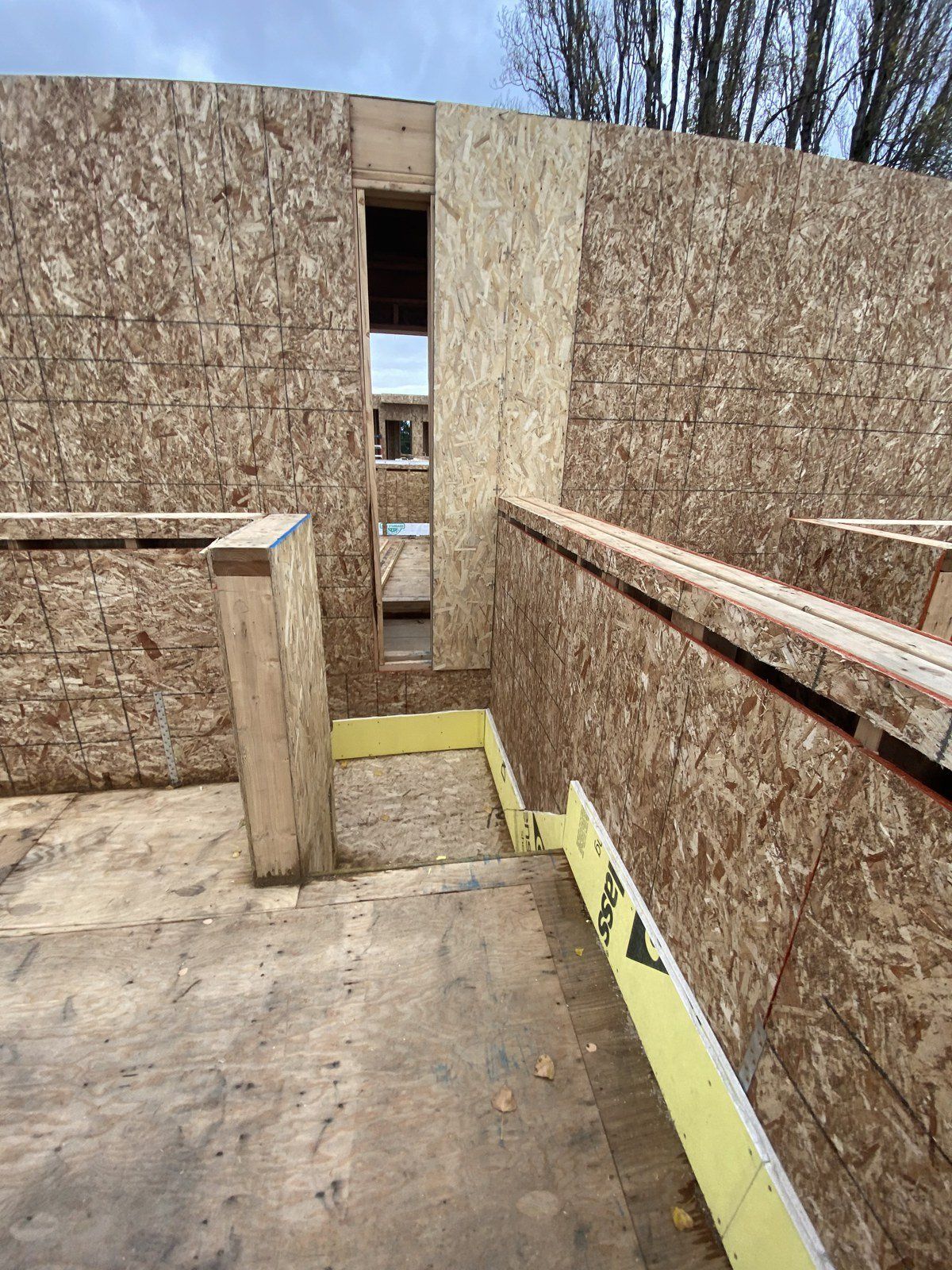 A house is being built with plywood walls and stairs.