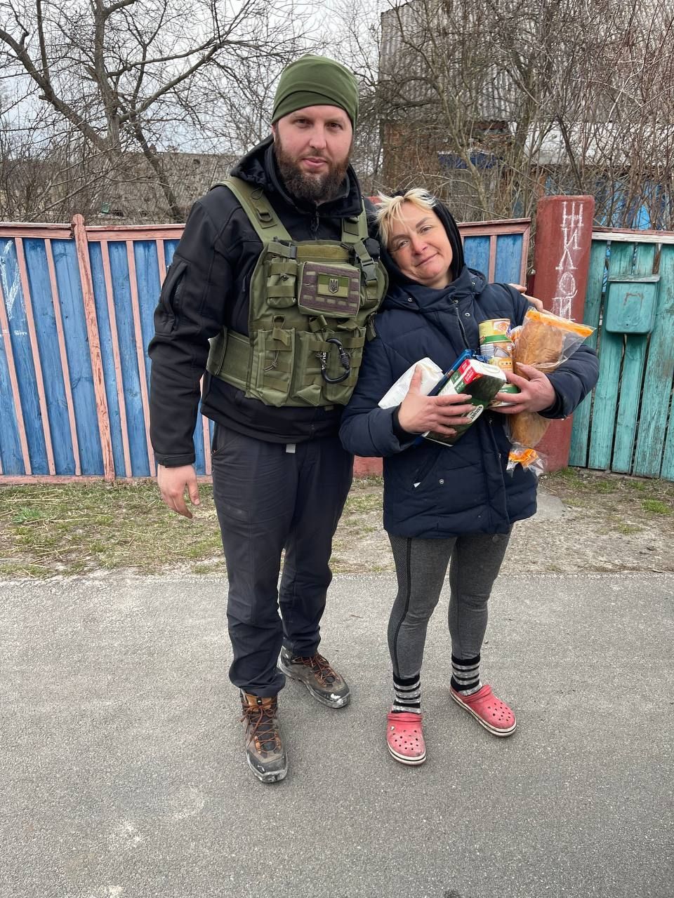 A man and a woman are standing next to each other on a sidewalk.