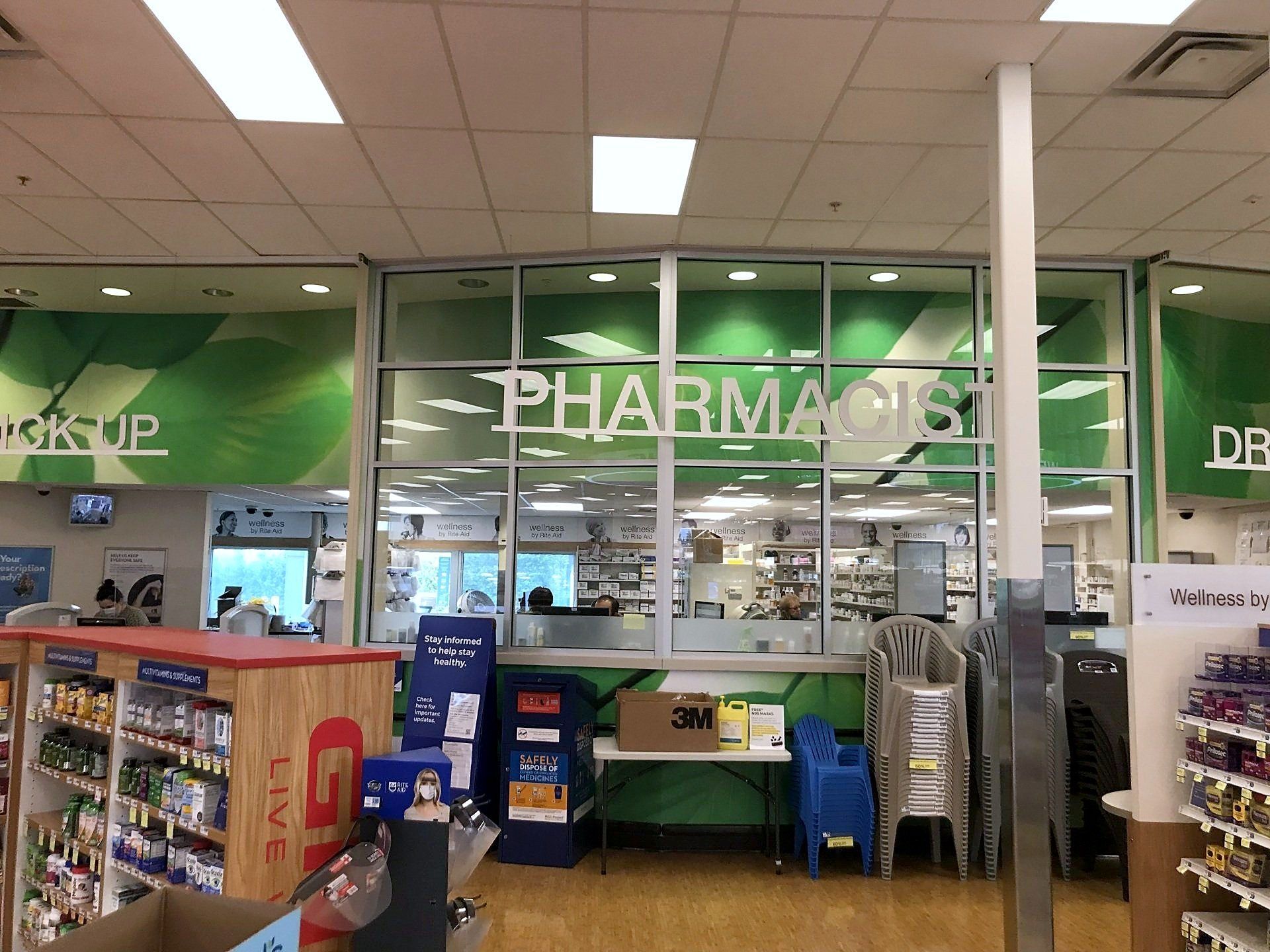 The front of a rite aid store against a blue sky.