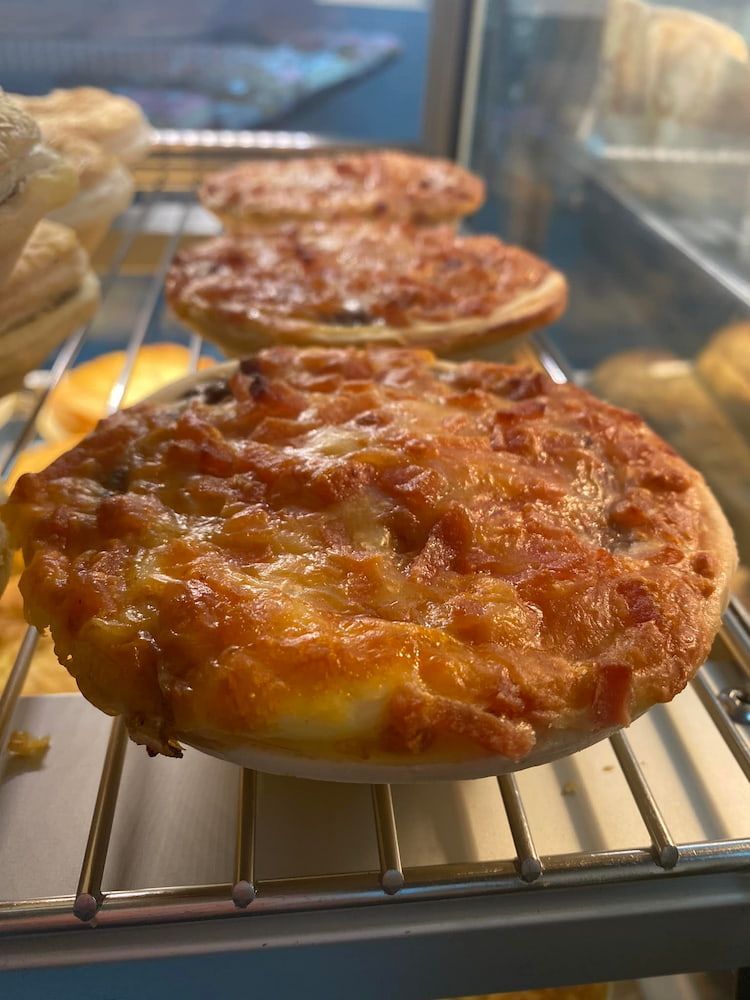 A Pie On A Rack In A Display Case — Cedar Park Bakehouse in Taranganba, QLD