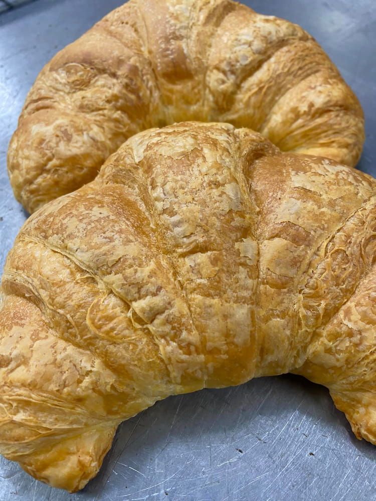 Two Croissants Are Sitting On Top Of Each Other On A Table — Cedar Park Bakehouse in Taranganba, QLD