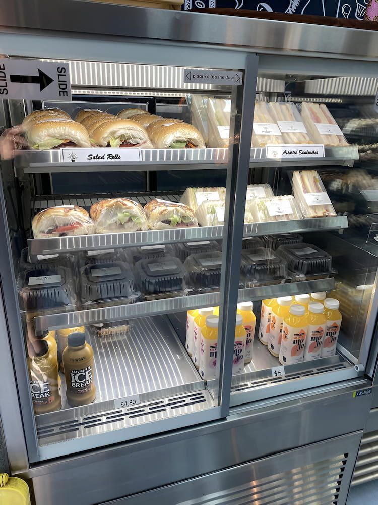 A Display Case Filled With Sandwiches And Drinks In A Restaurant — Cedar Park Bakehouse in Taranganba, QLD
