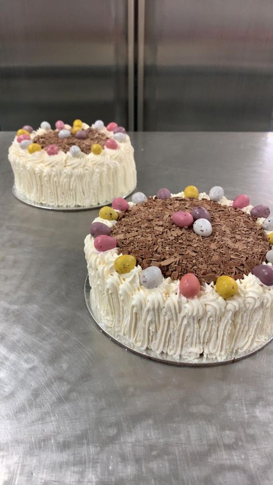 Two Cakes Are Sitting On Top Of A Metal Table — Cedar Park Bakehouse in Taranganba, QLD