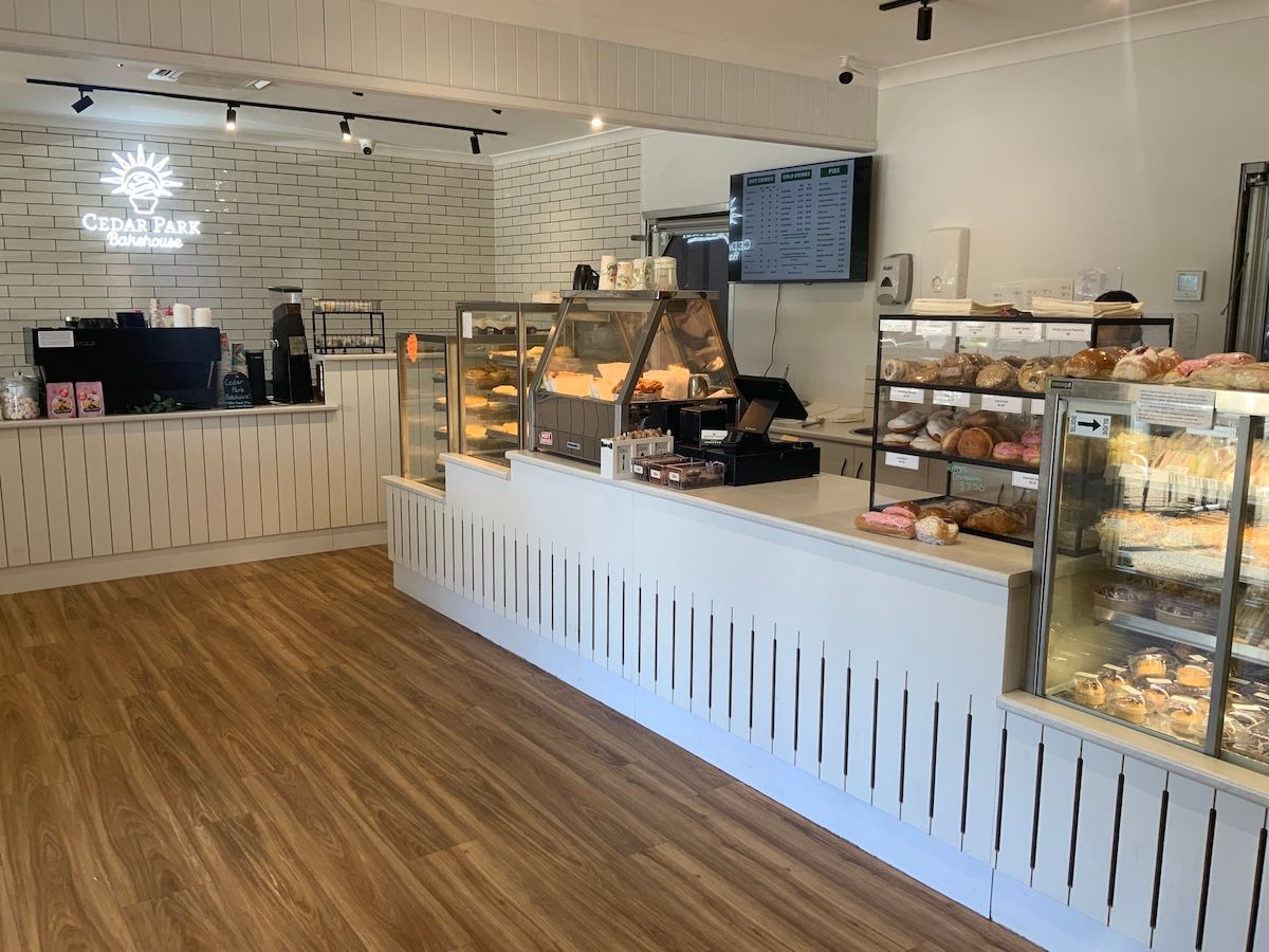 Bright bakery cafe counter with glass pastry displays — Cedar Park Bakehouse in Taranganba, QLD